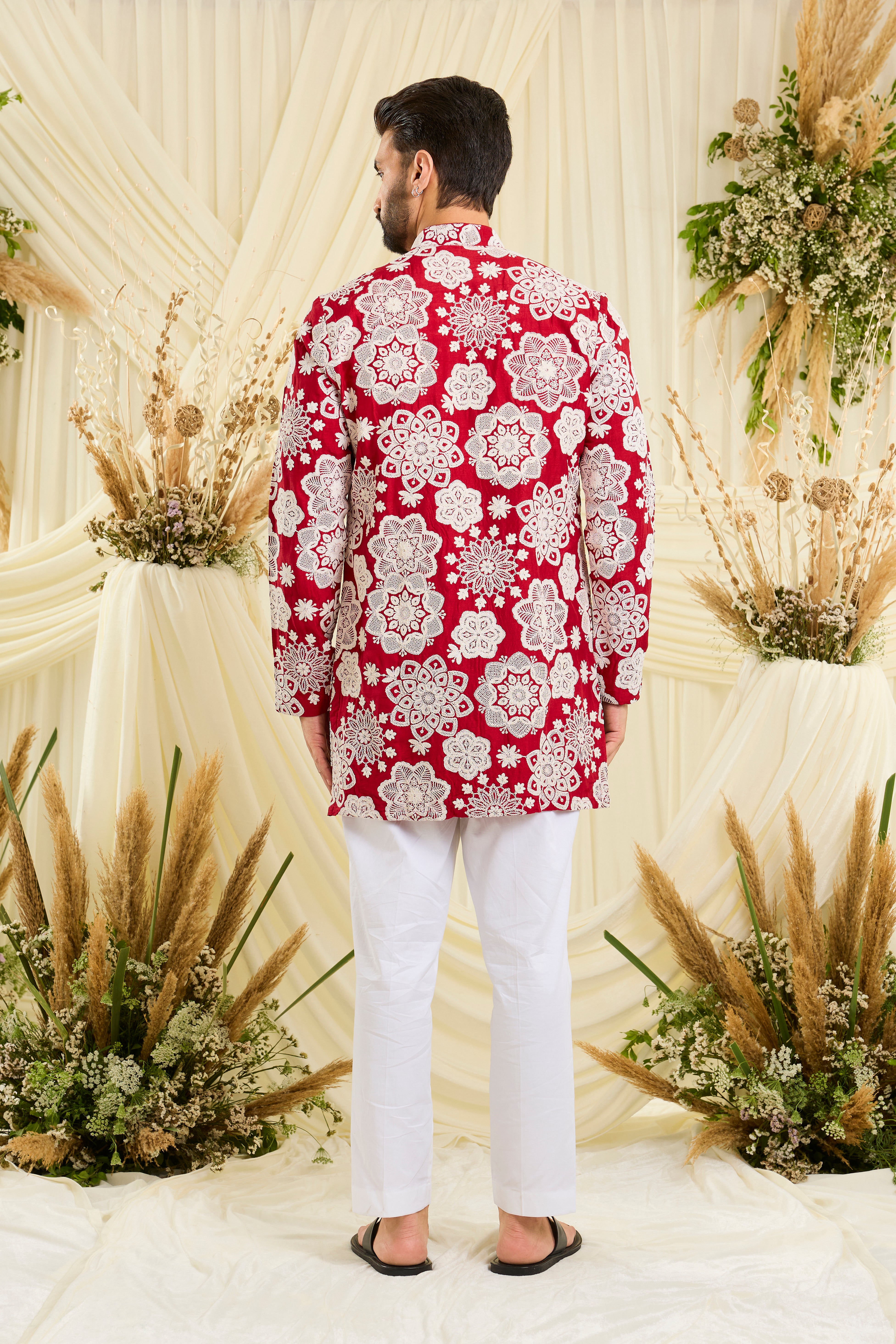 Red short kurta with intricate floral embroidery and heavy dori work, delivering a richly textured, bold festive statement.