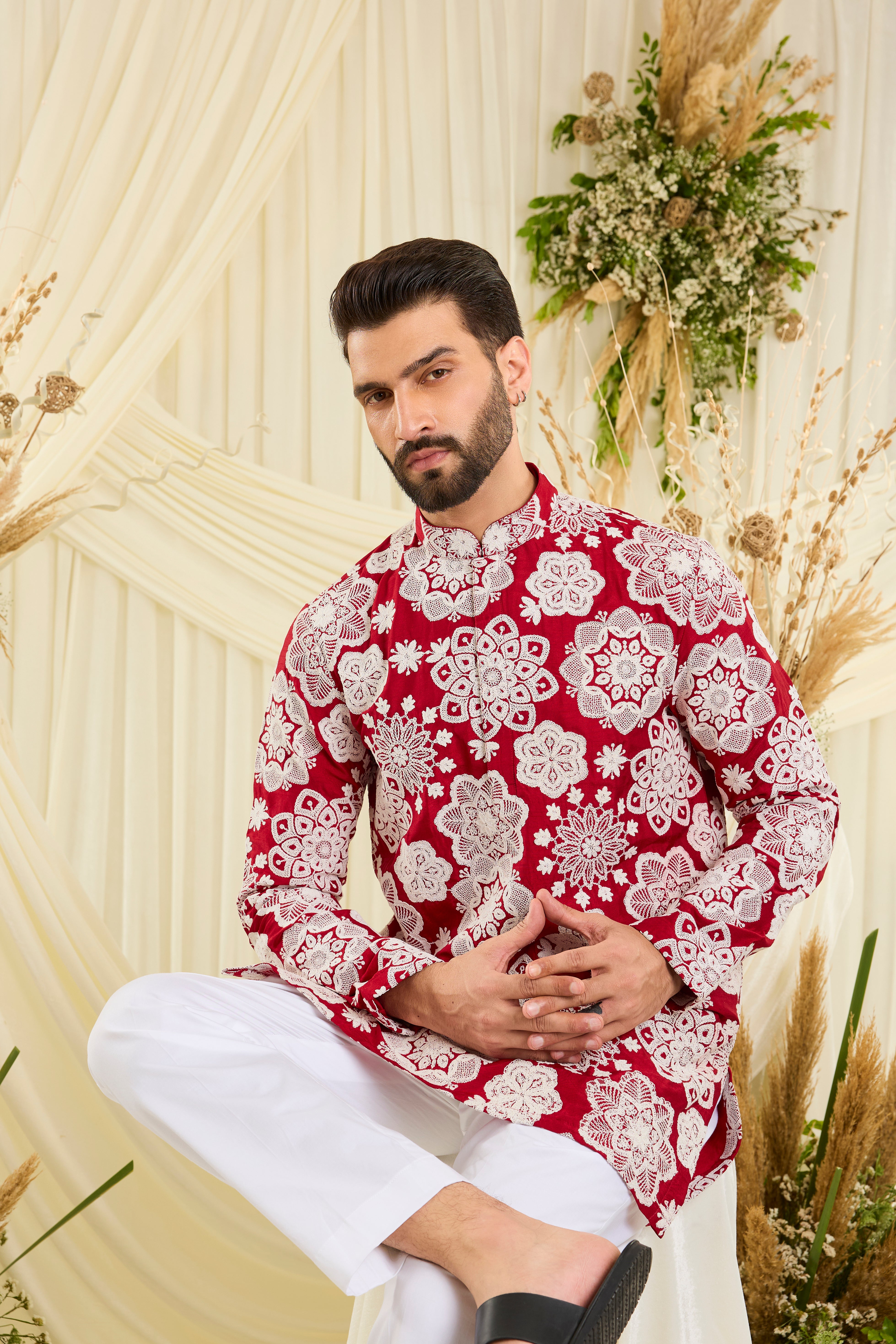 Red short kurta with intricate floral embroidery and heavy dori work, delivering a richly textured, bold festive statement.