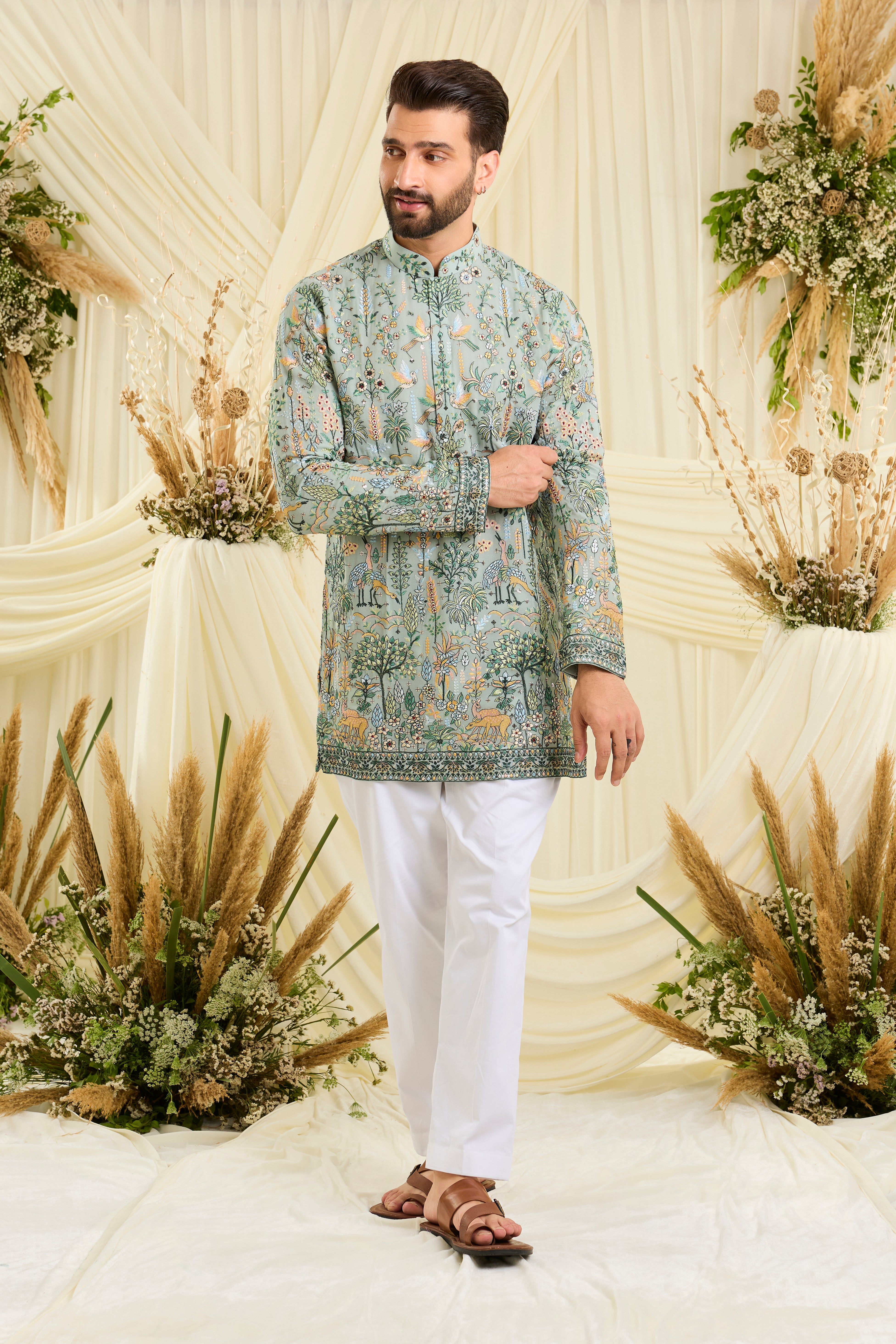 Bluish green short kurta with intricate flora-fauna embroidery, multicolour threadwork, and delicate sequins for a fresh, elevated festive look.