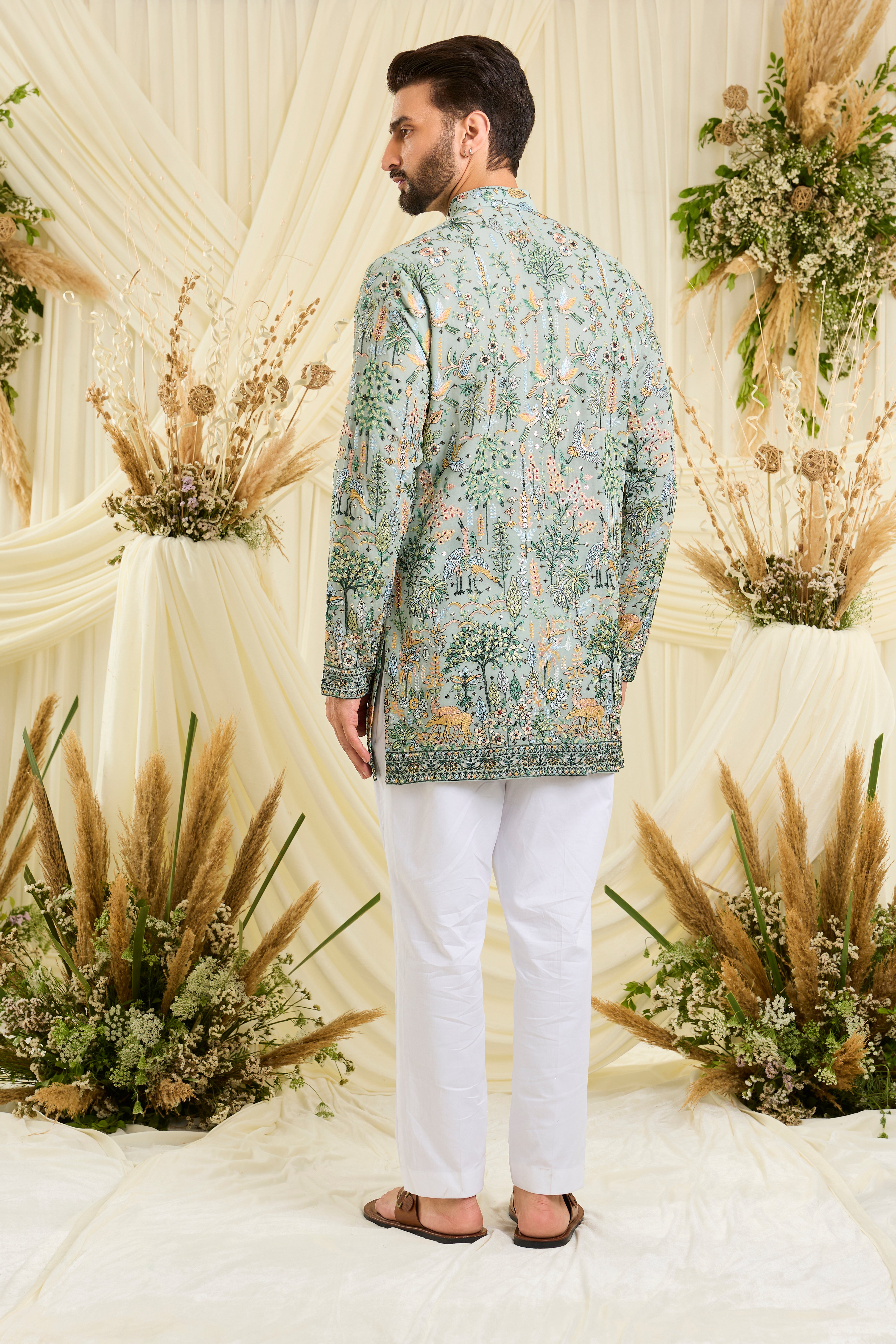 Bluish green short kurta with intricate flora-fauna embroidery, multicolour threadwork, and delicate sequins for a fresh, elevated festive look.