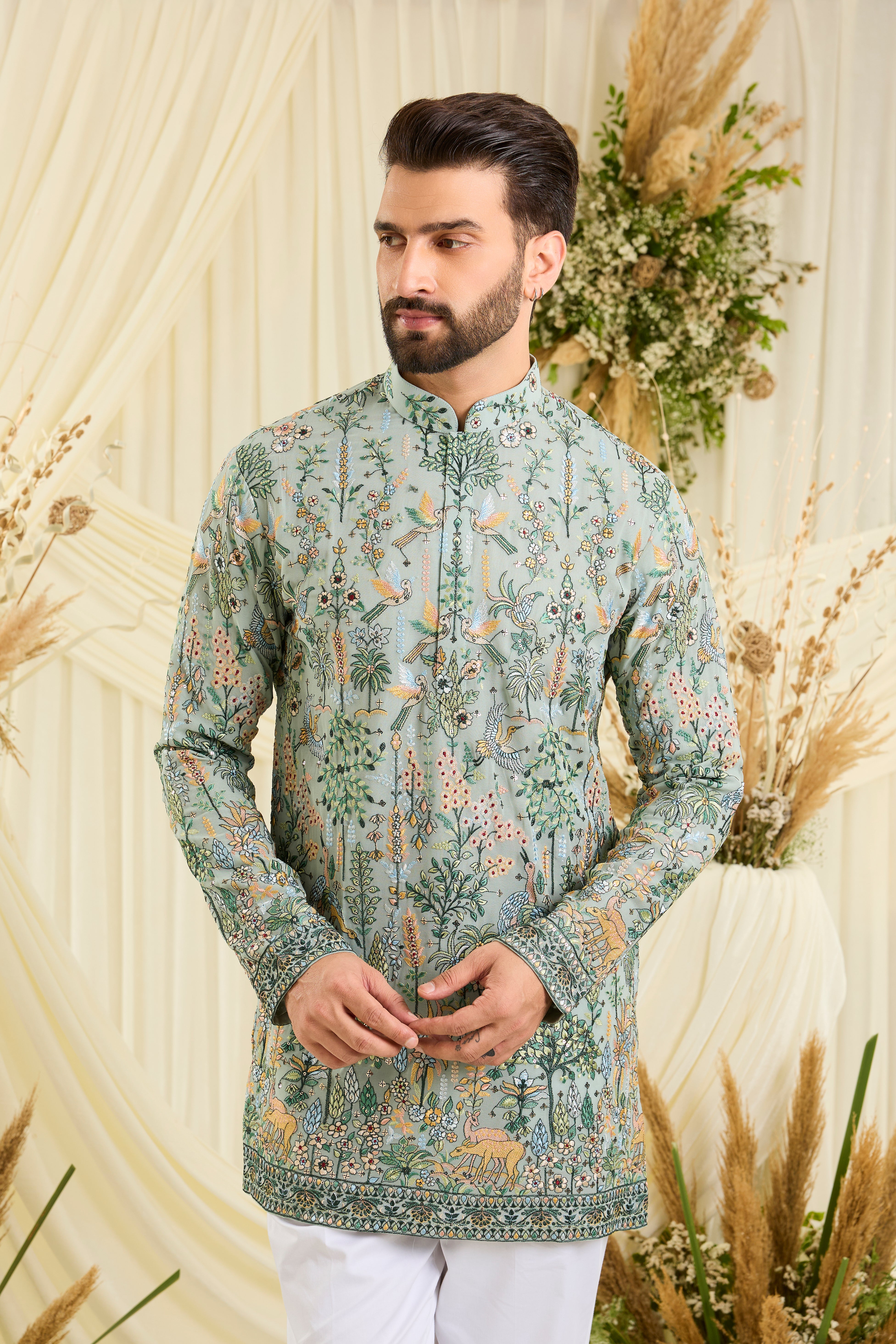 Bluish green short kurta with intricate flora-fauna embroidery, multicolour threadwork, and delicate sequins for a fresh, elevated festive look.