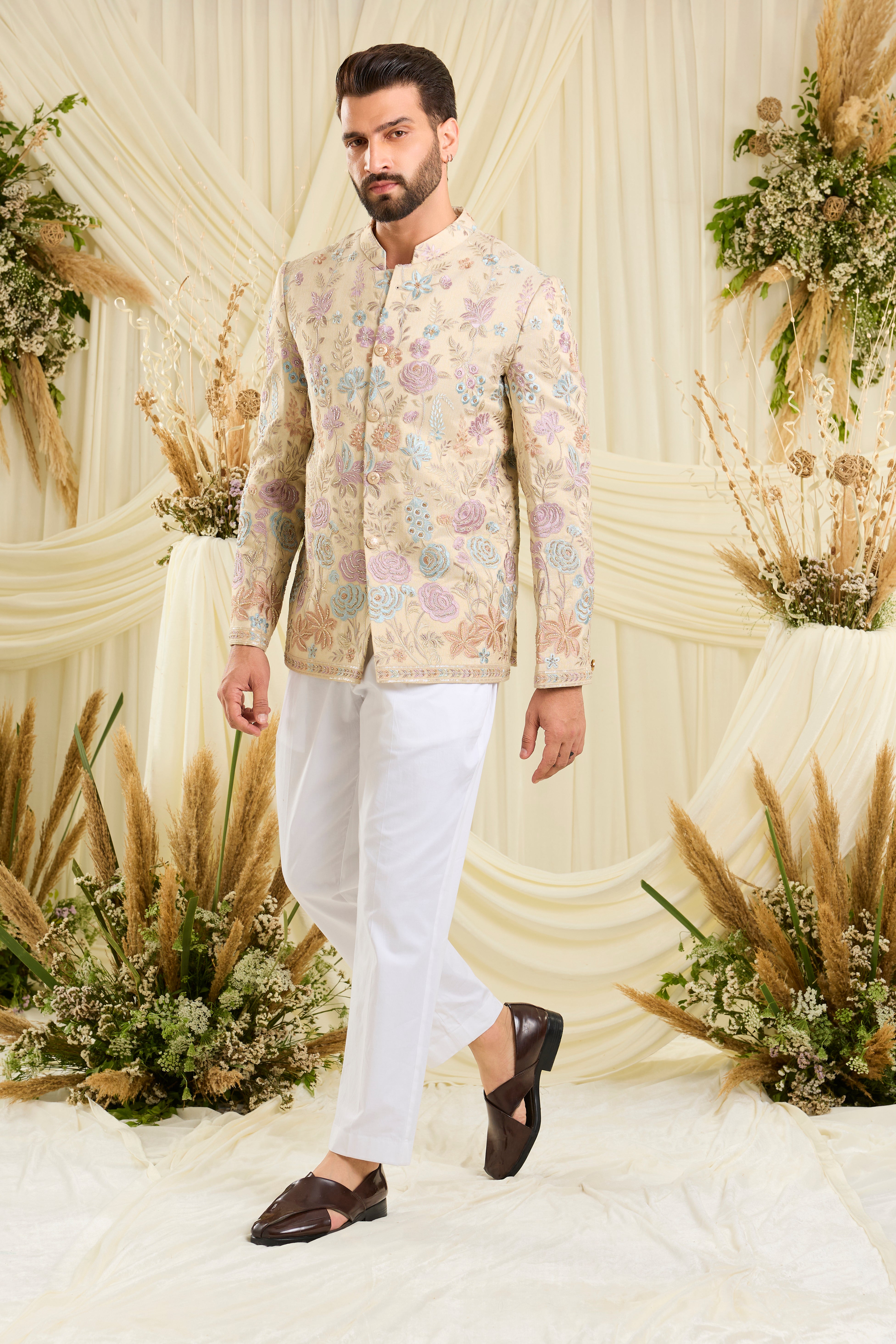 Cream-gold bandhgala with floral embroidery, multicolour threadwork, and cut dana detailing — regal, luminous, and effortlessly sophisticated.
