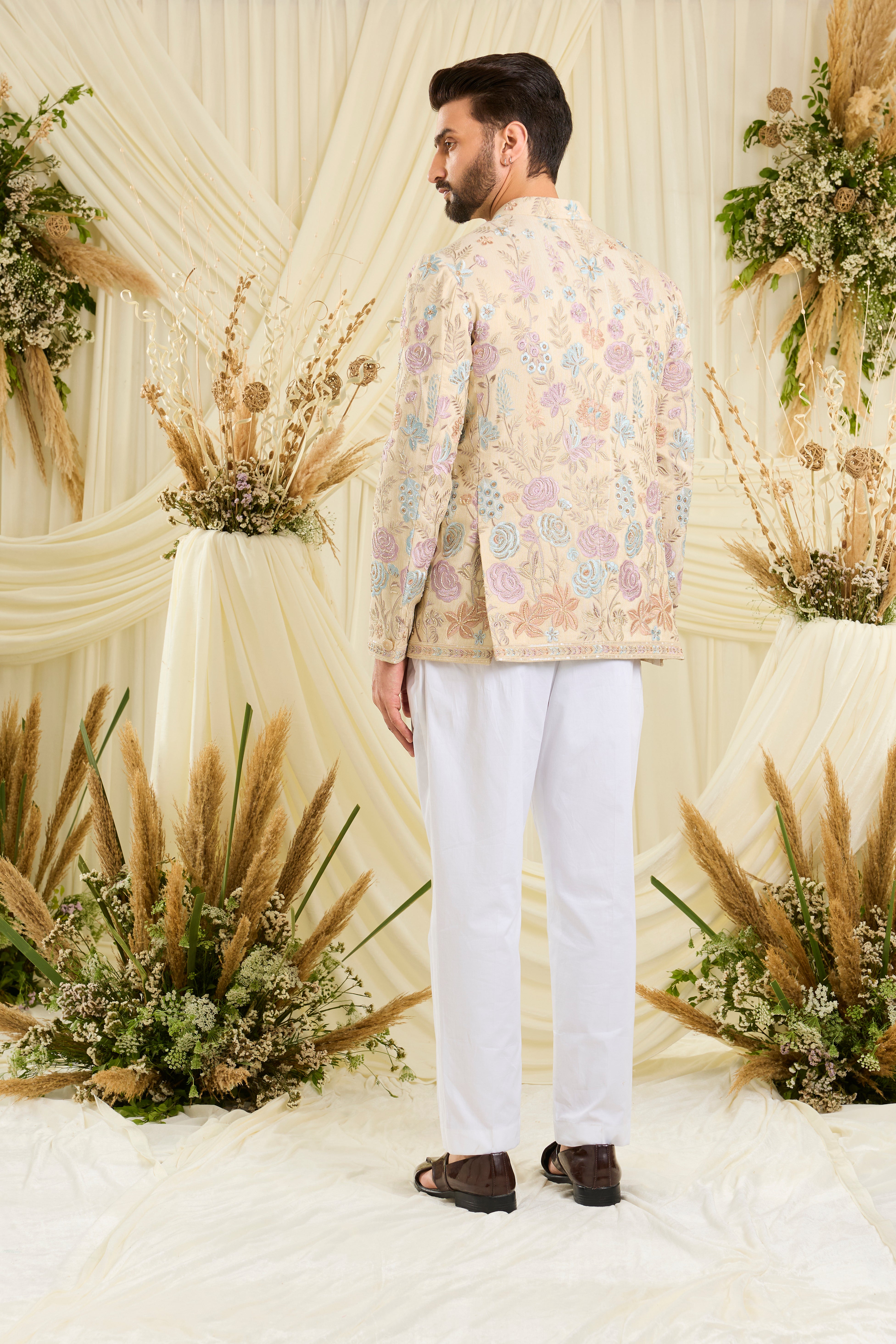 Cream-gold bandhgala with floral embroidery, multicolour threadwork, and cut dana detailing — regal, luminous, and effortlessly sophisticated.