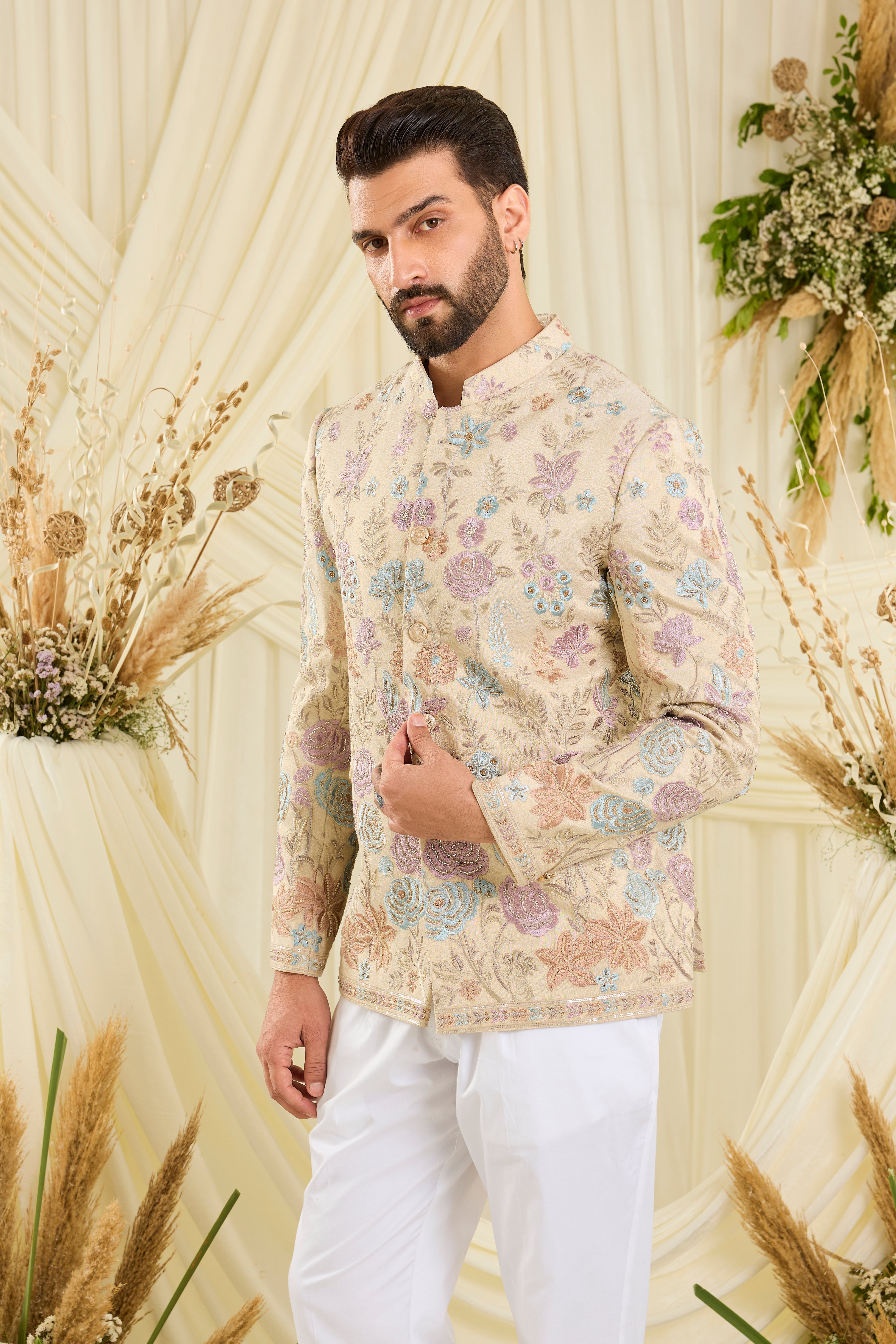 Cream-gold bandhgala with floral embroidery, multicolour threadwork, and cut dana detailing — regal, luminous, and effortlessly sophisticated.
