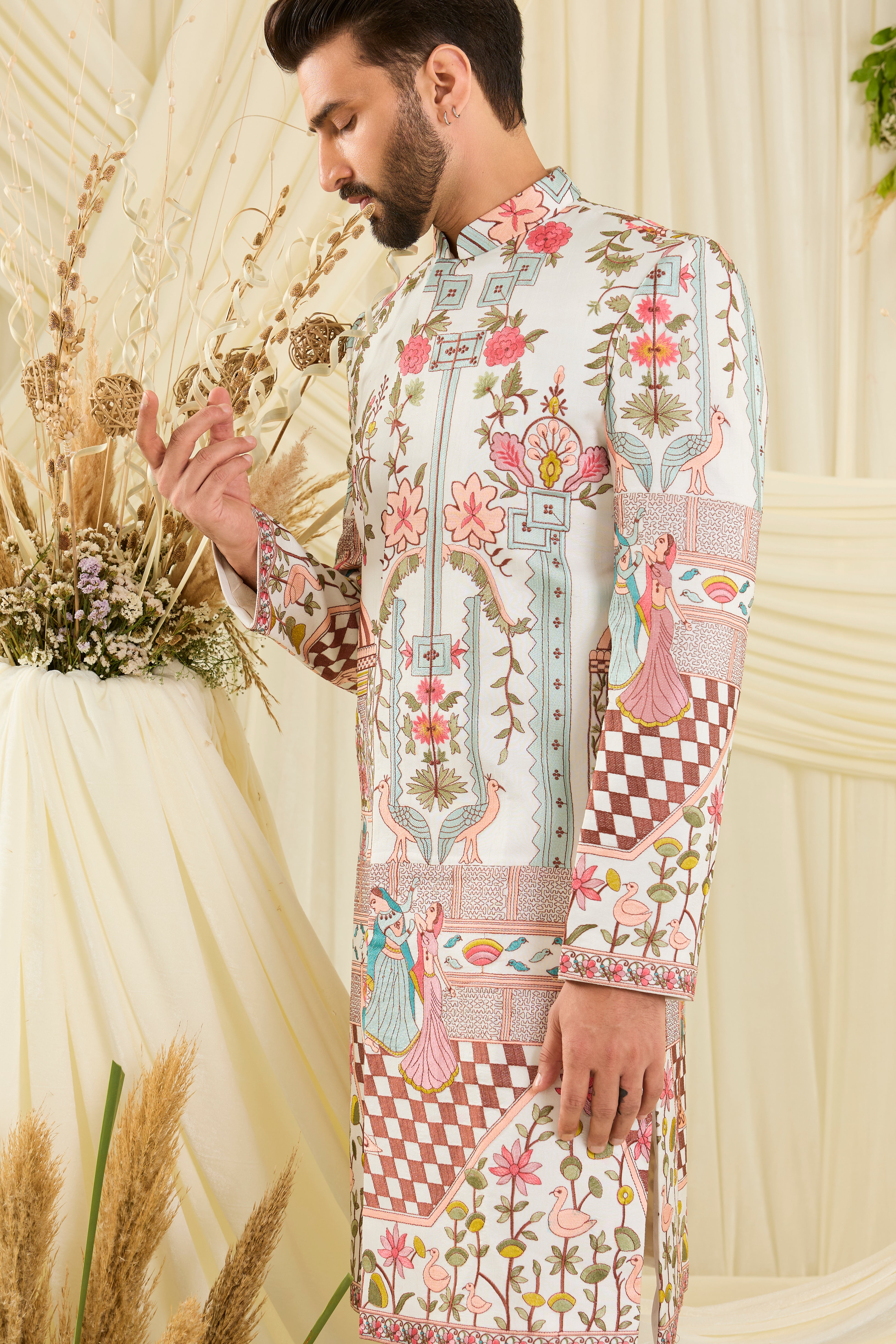 Opulent silk sherwani with Mughal darbars, peacocks, florals, and dancing royals — a masterpiece of imperial artistry.