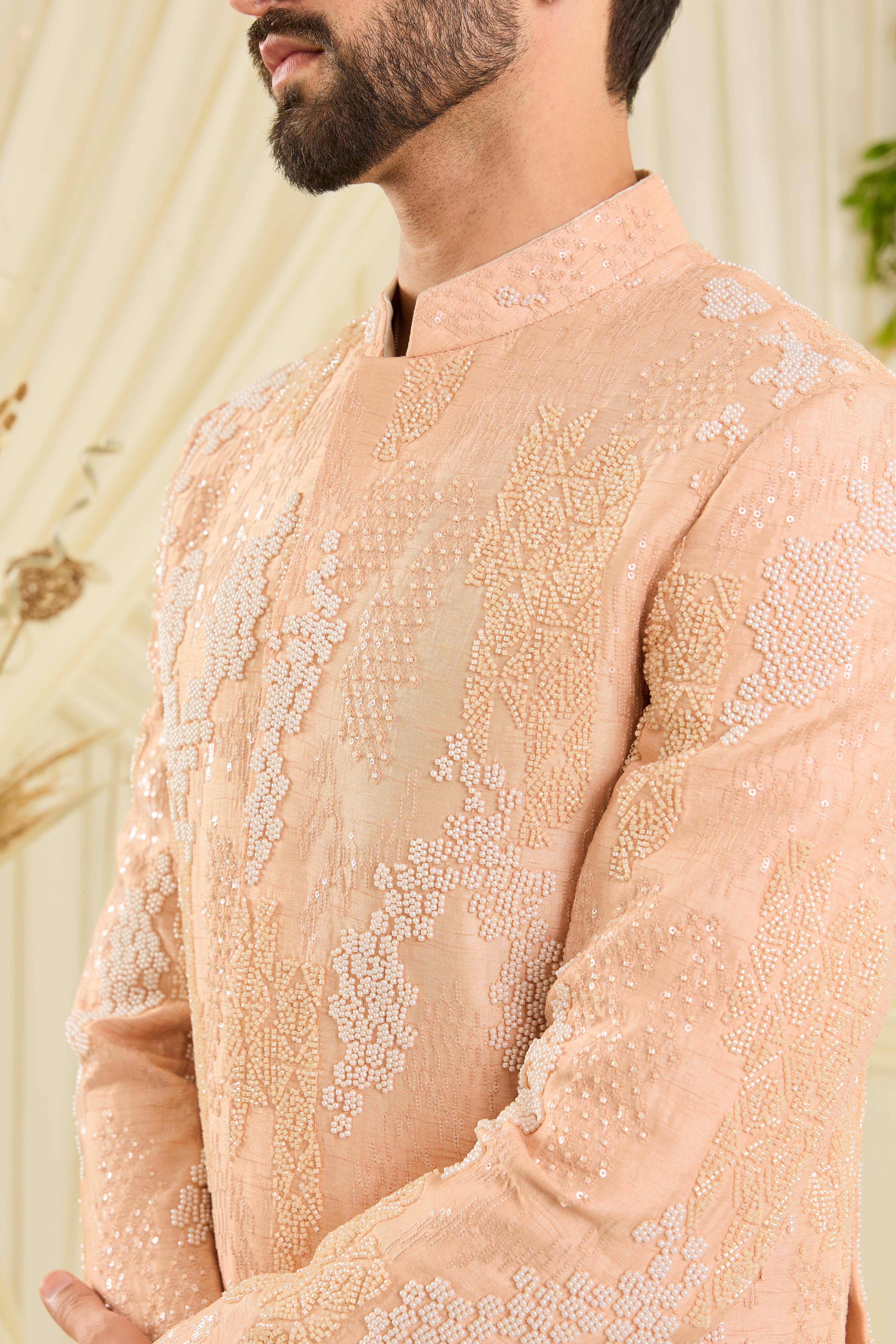 Peach bandhgala with hand embroidery, tonal cut dana, and ivory beads — impeccably regal, refined, and royally luxurious.