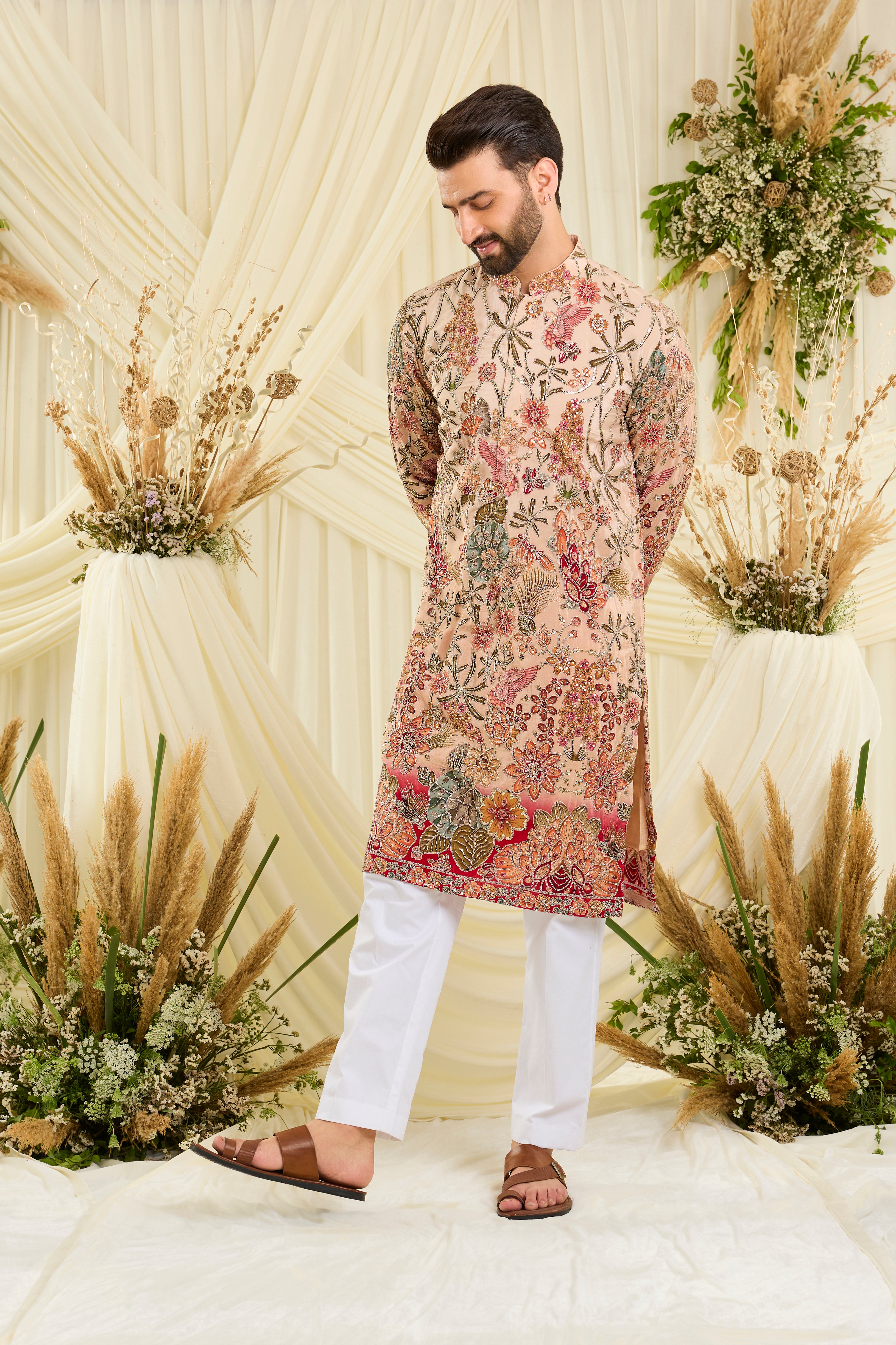 Pastel peach kurta with intricate floral embroidery, rich zari detailing, and delicate sequins for a refined, luminous festive statement.