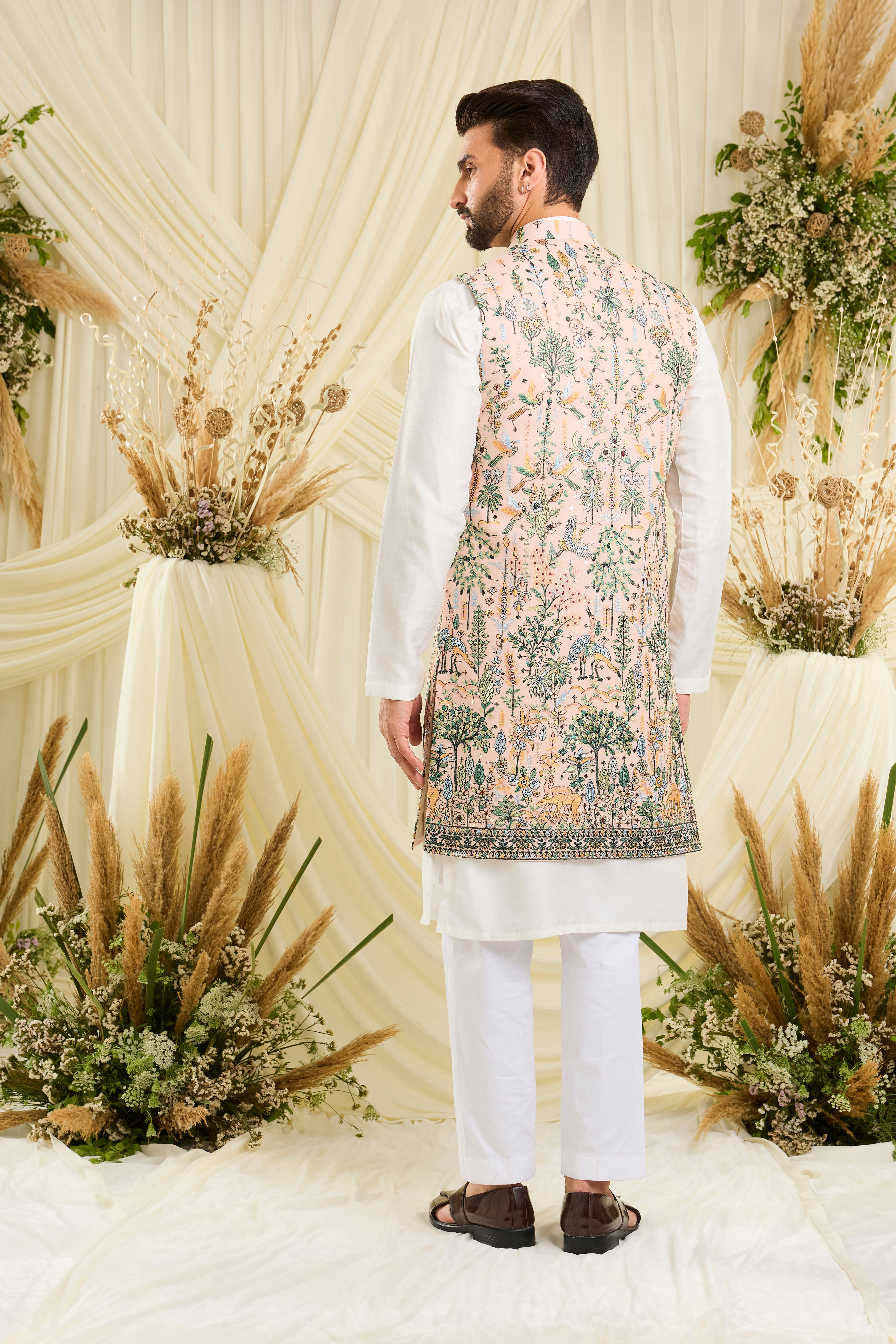 Light peach long open jacket with intricate flora-fauna embroidery, multicolour threadwork, and delicate sequins for a fresh, elevated festive look.
