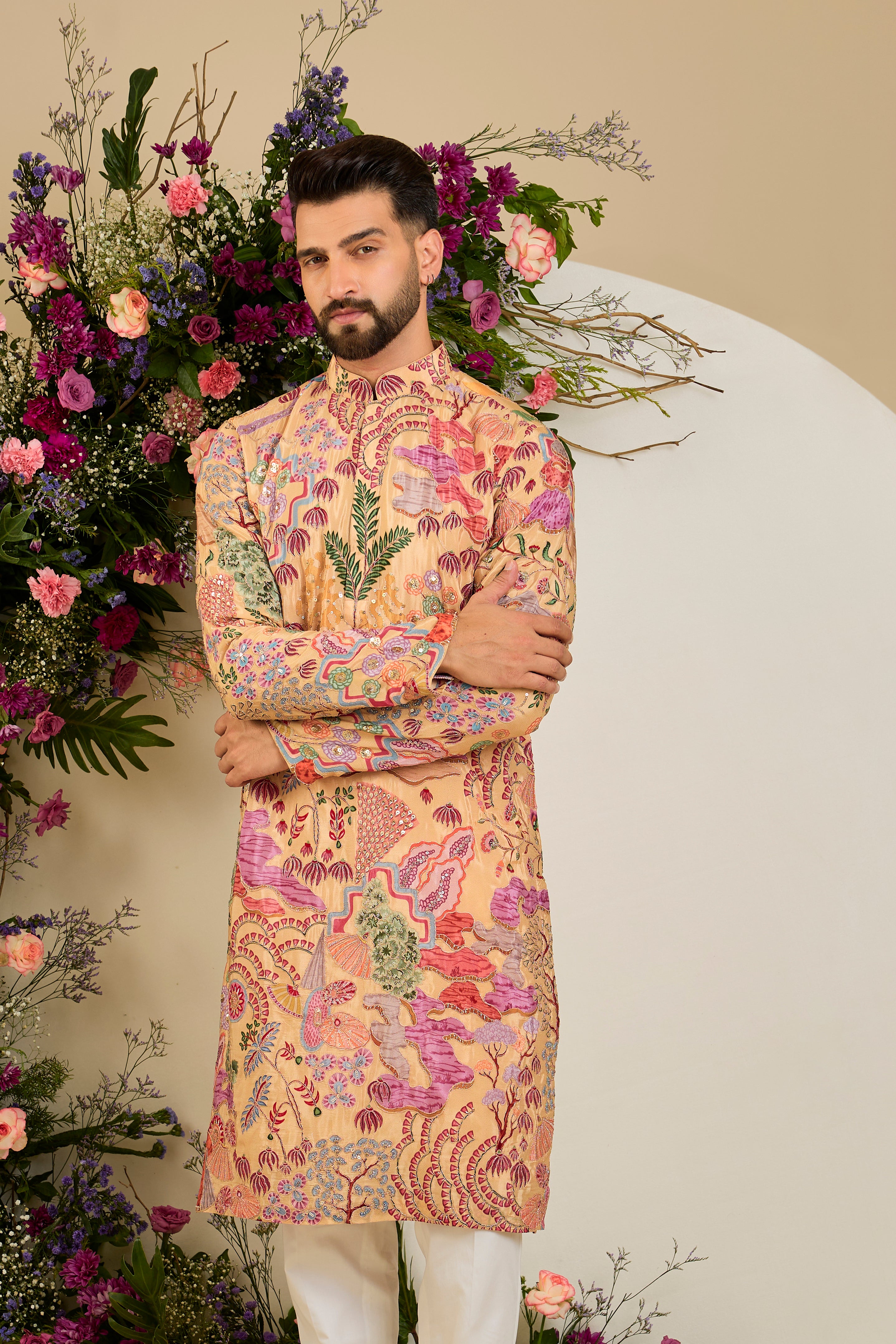 Tan peach crepe kurta with a botanical print, refined zari embroidery, and delicate sequin detailing for elevated occasion dressing.