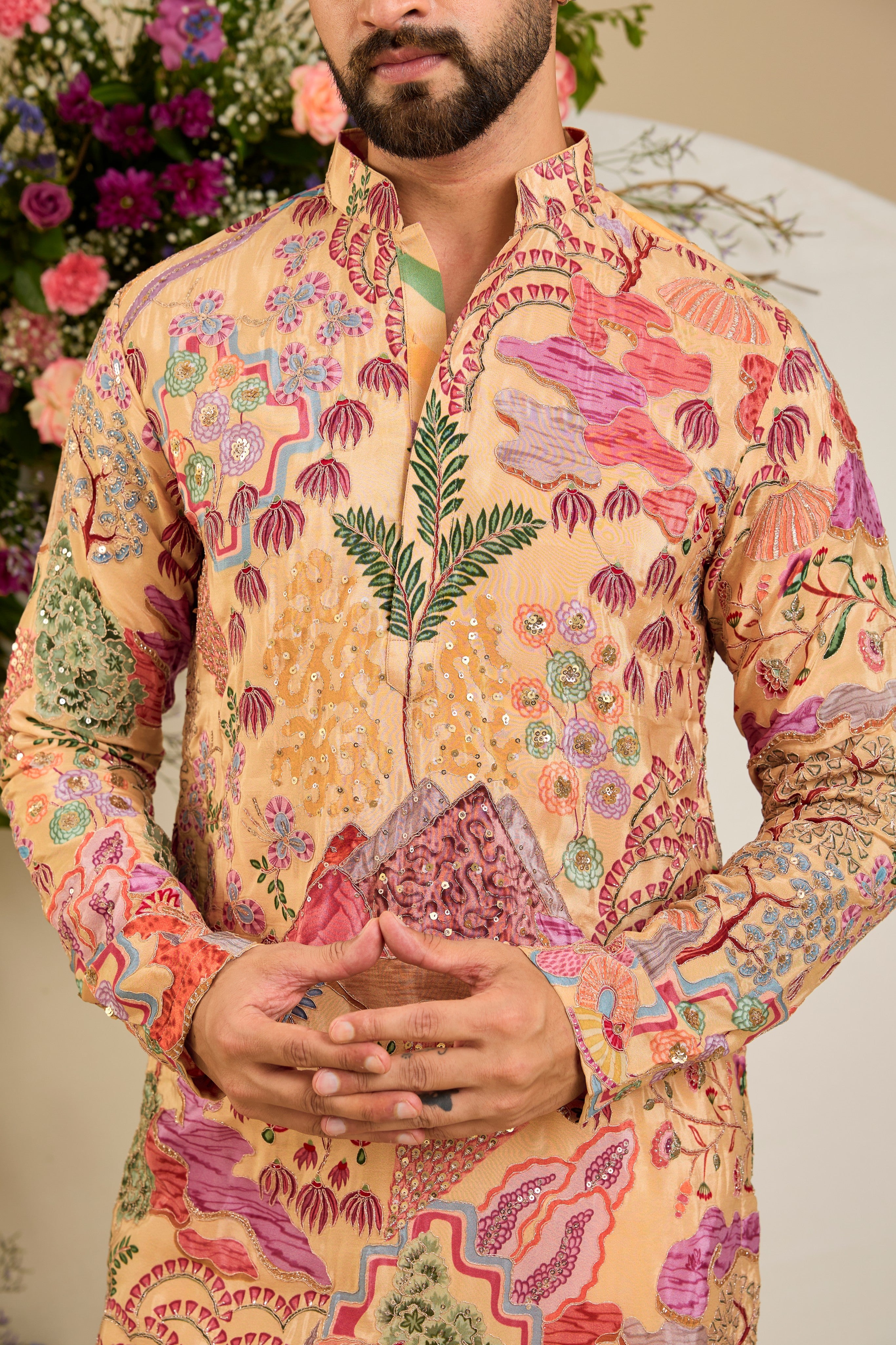 Tan peach crepe kurta with a botanical print, refined zari embroidery, and delicate sequin detailing for elevated occasion dressing.