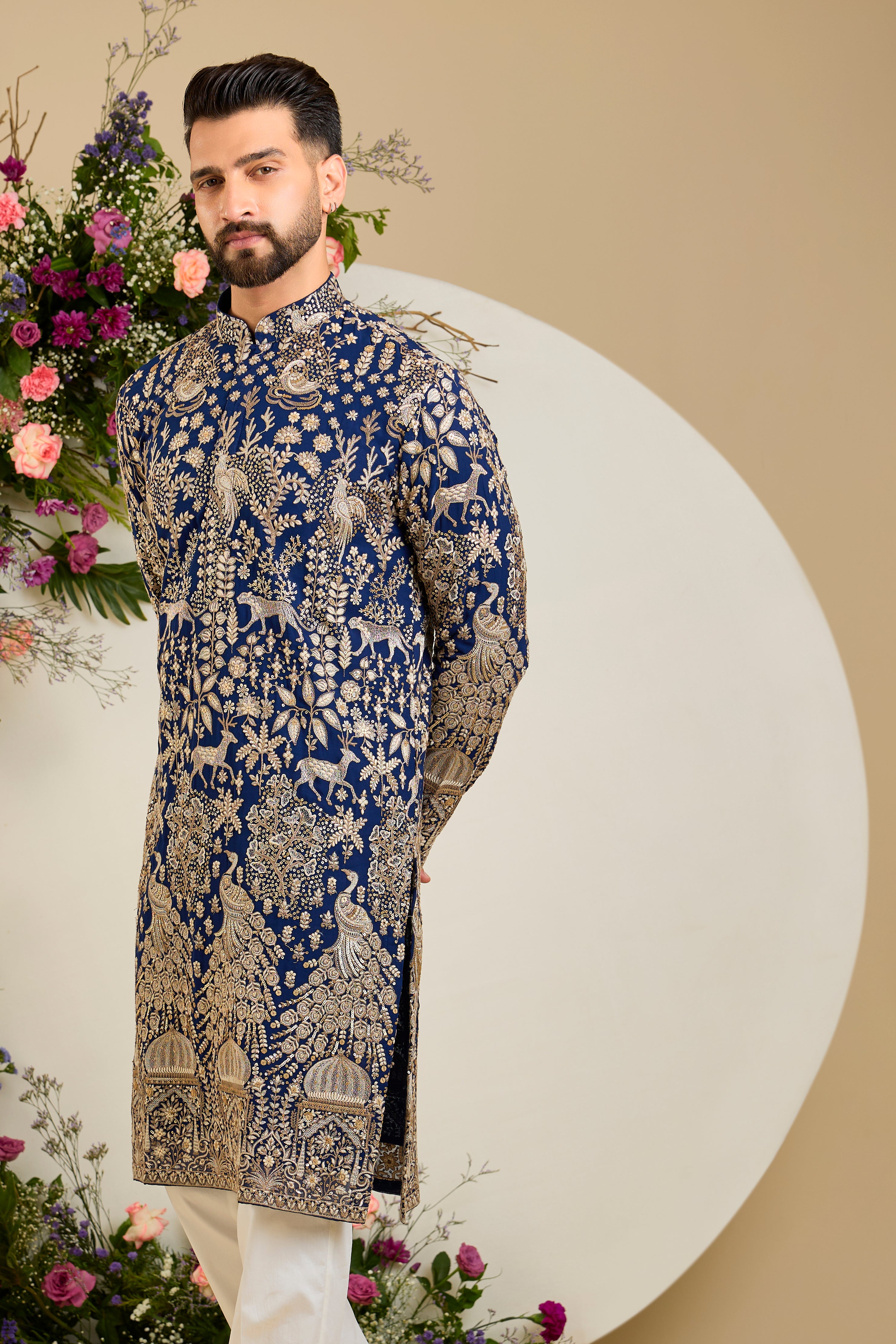 Royal blue heritage kurta with Mughal domes, peacocks, lions, heavy zari embroidery, and refined sequin detailing.
