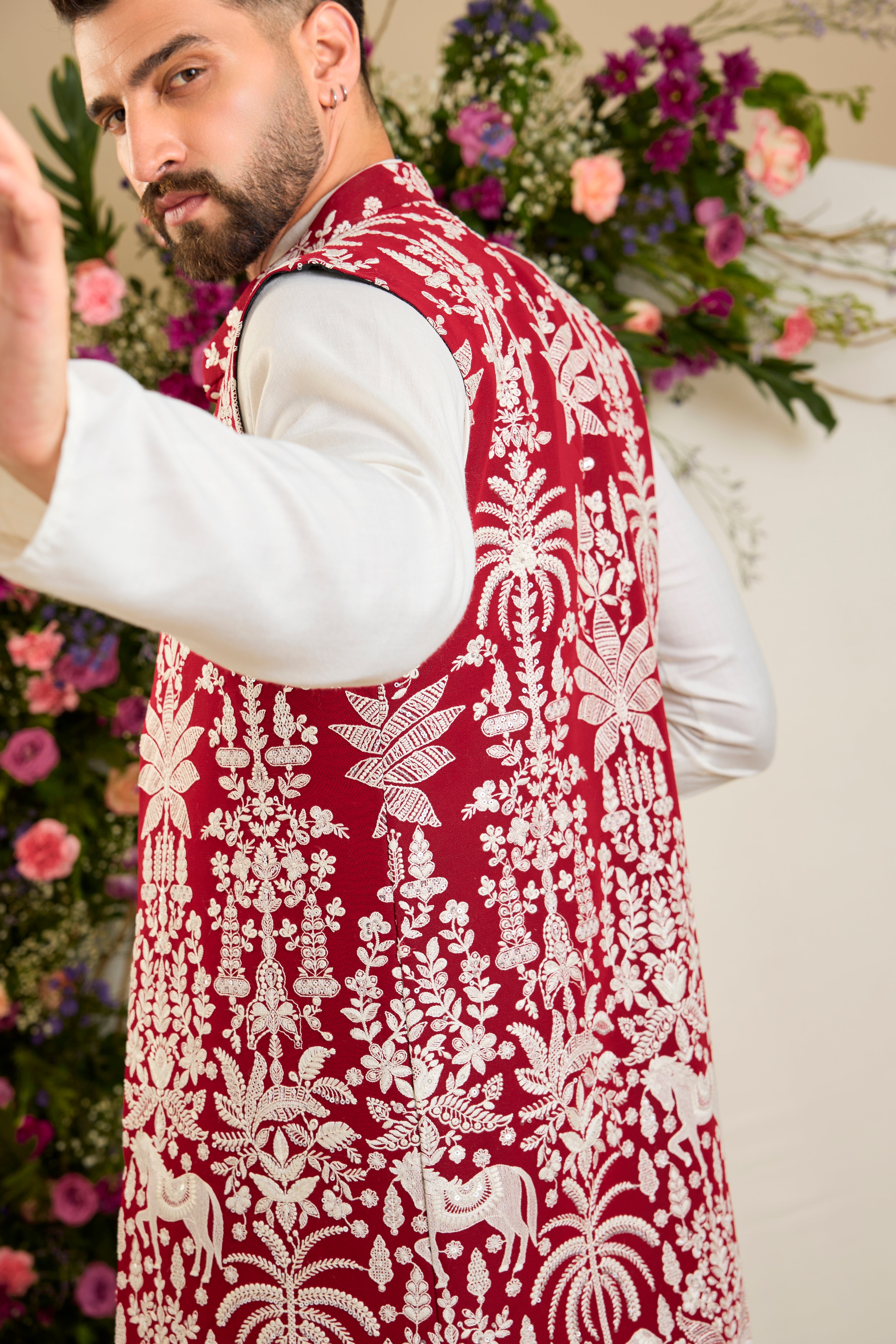 Red long open jacket with tropical flora and fauna embroidery, ivory threadwork, and delicate sequin detailing for refined occasion wear.