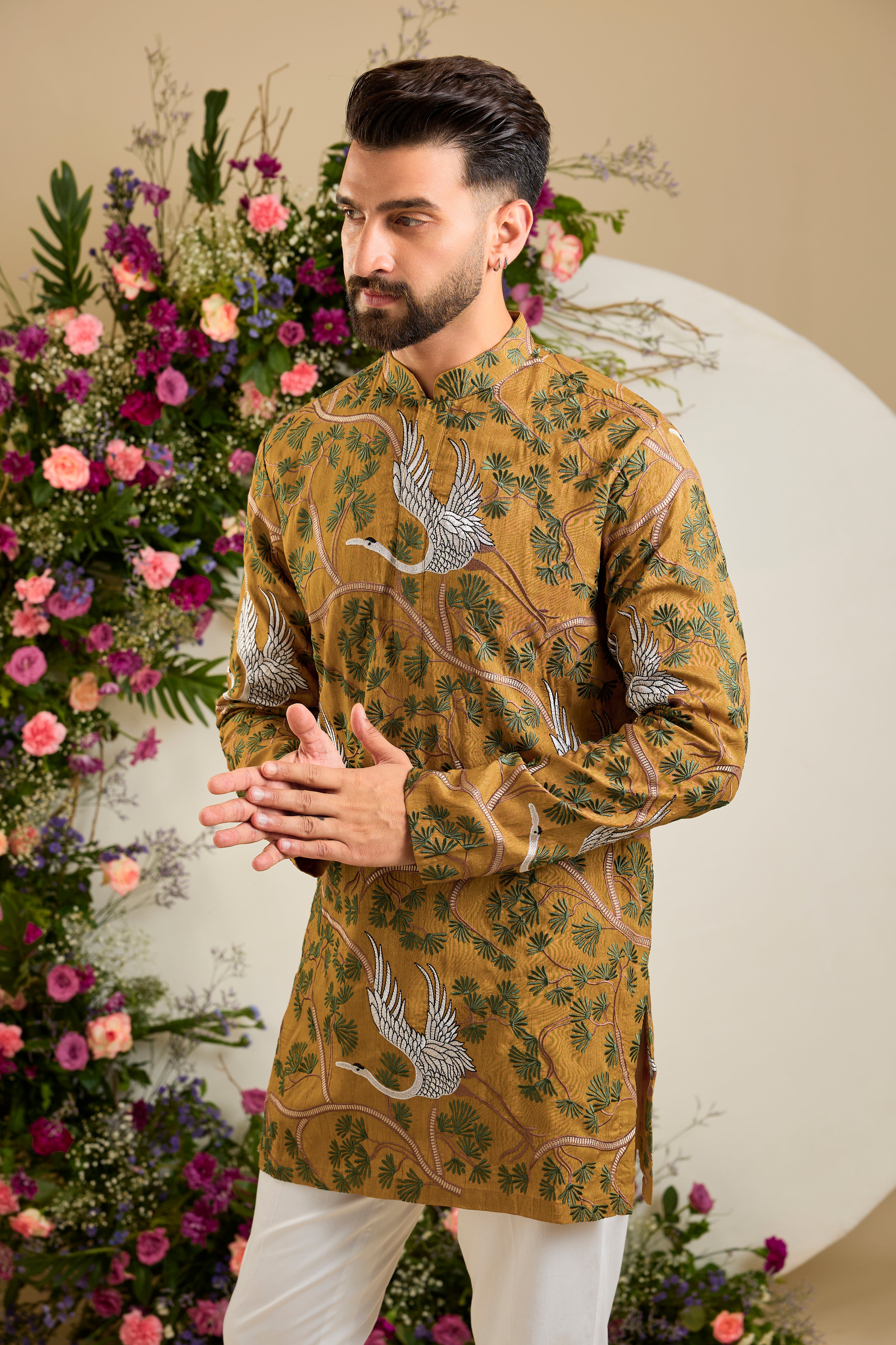 Mustard short kurta with a tropical backdrop, graceful flamingo motifs, intricate threadwork, and delicate sequin embellishments.