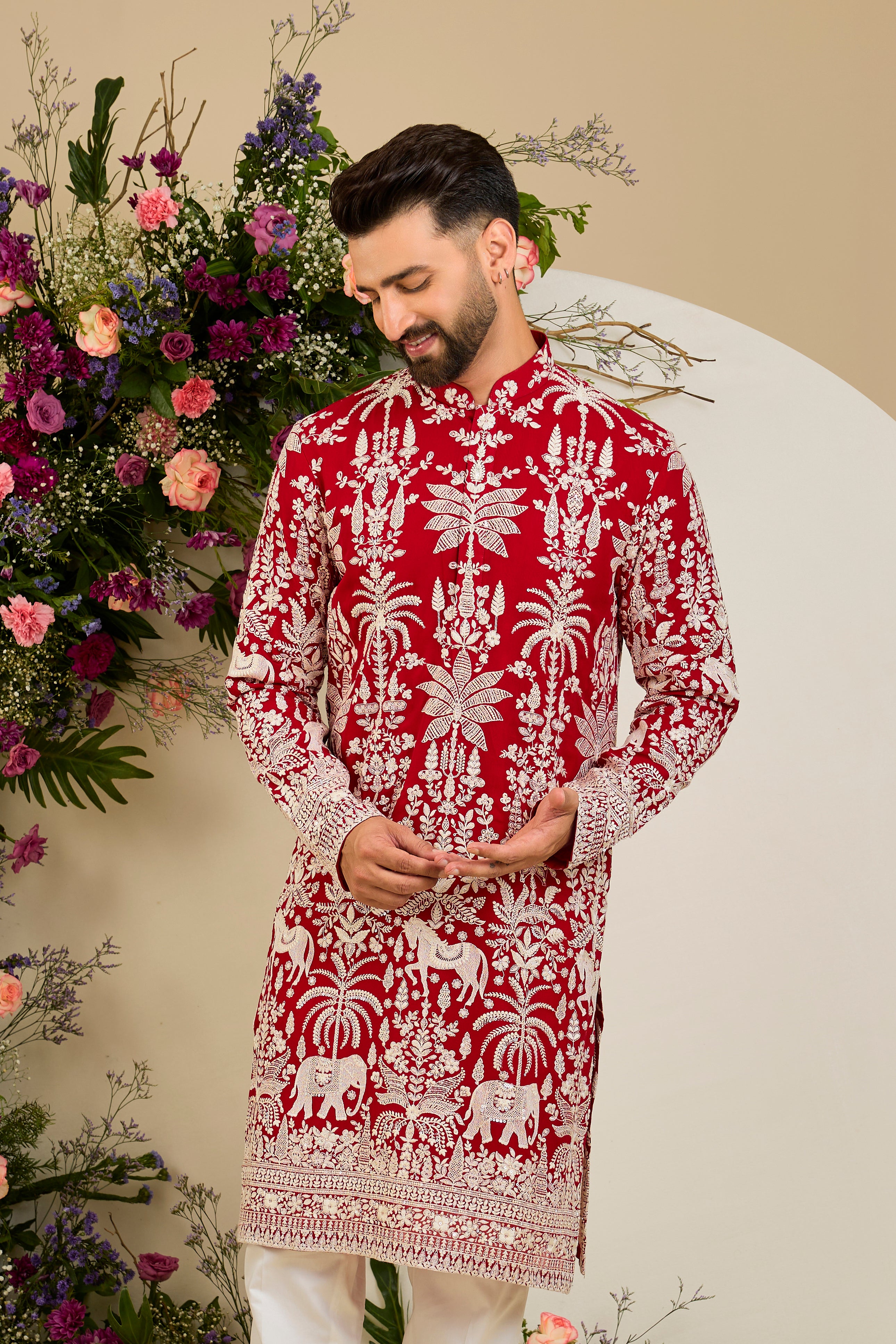 Red kurta with tropical flora and fauna embroidery, ivory threadwork, and delicate sequin detailing for refined occasion wear.