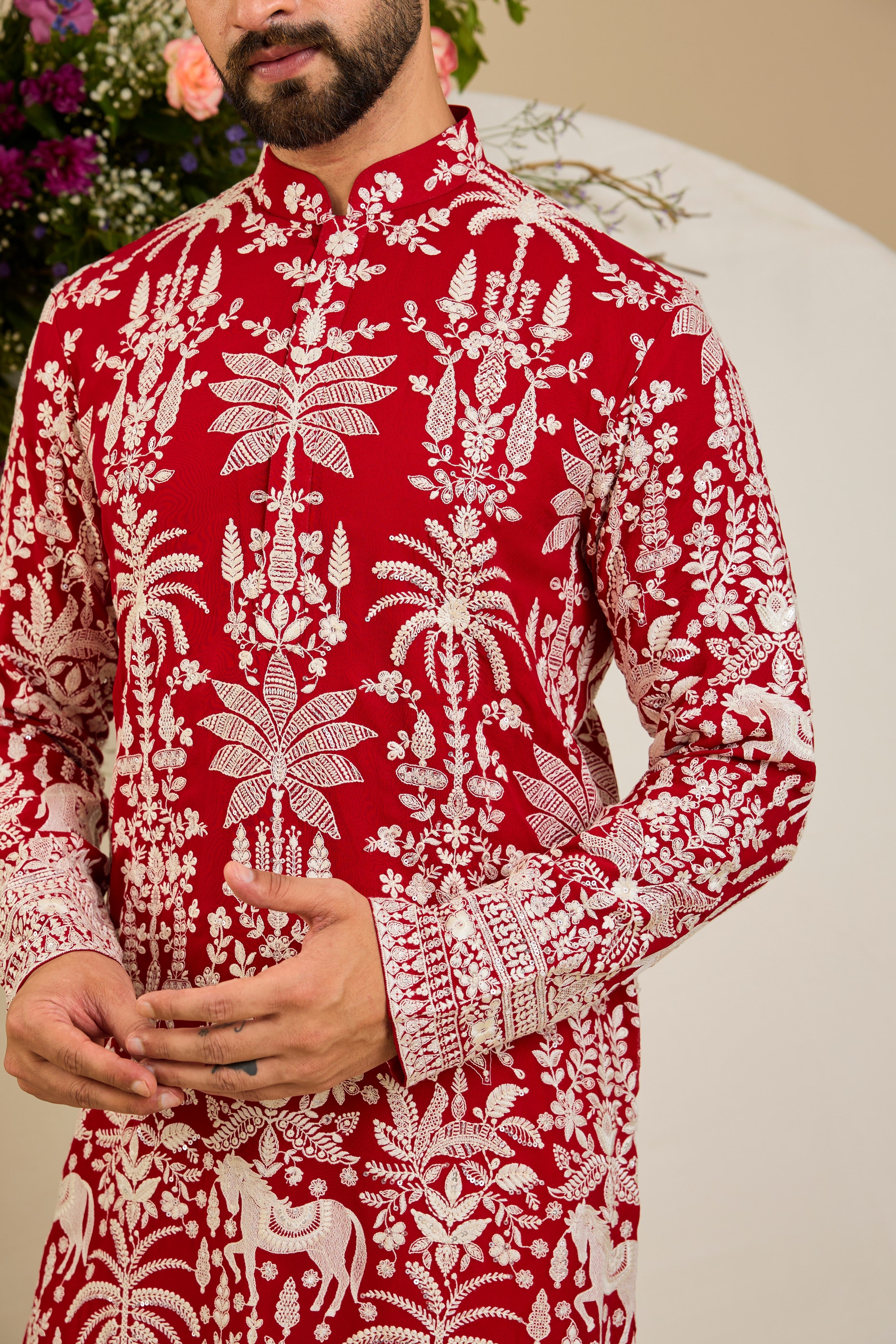 Red kurta with tropical flora and fauna embroidery, ivory threadwork, and delicate sequin detailing for refined occasion wear.