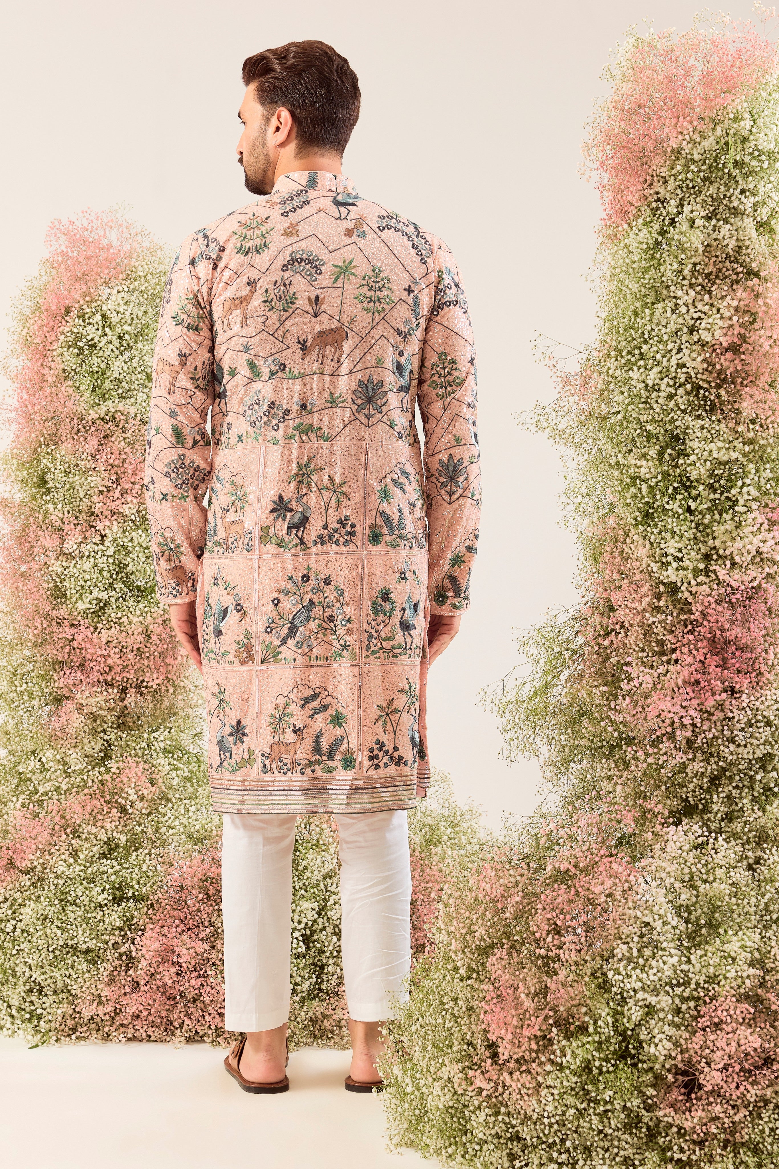 peach sequined kurta with detailed flora and fauna figures and intricate neckline