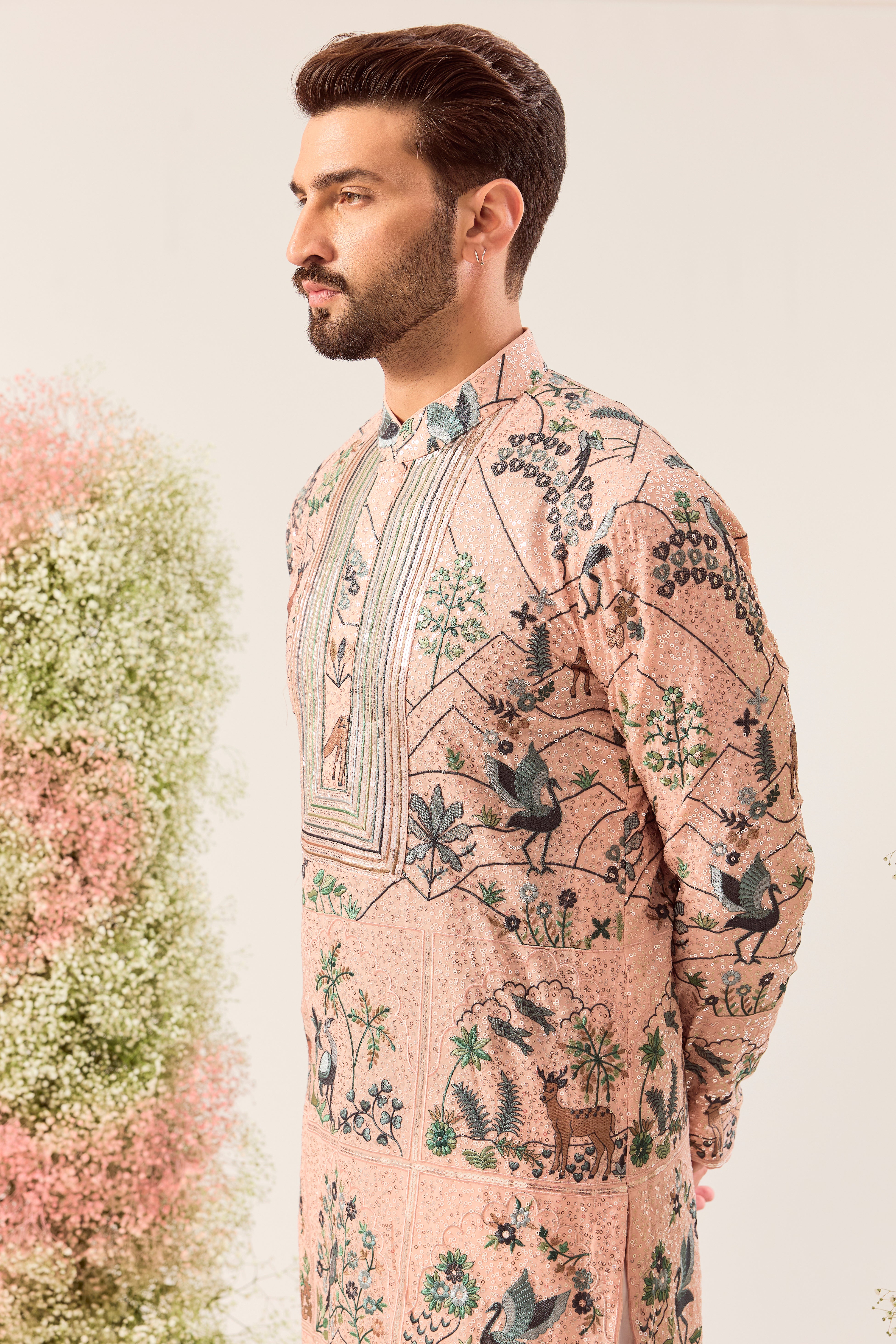 peach sequined kurta with detailed flora and fauna figures and intricate neckline