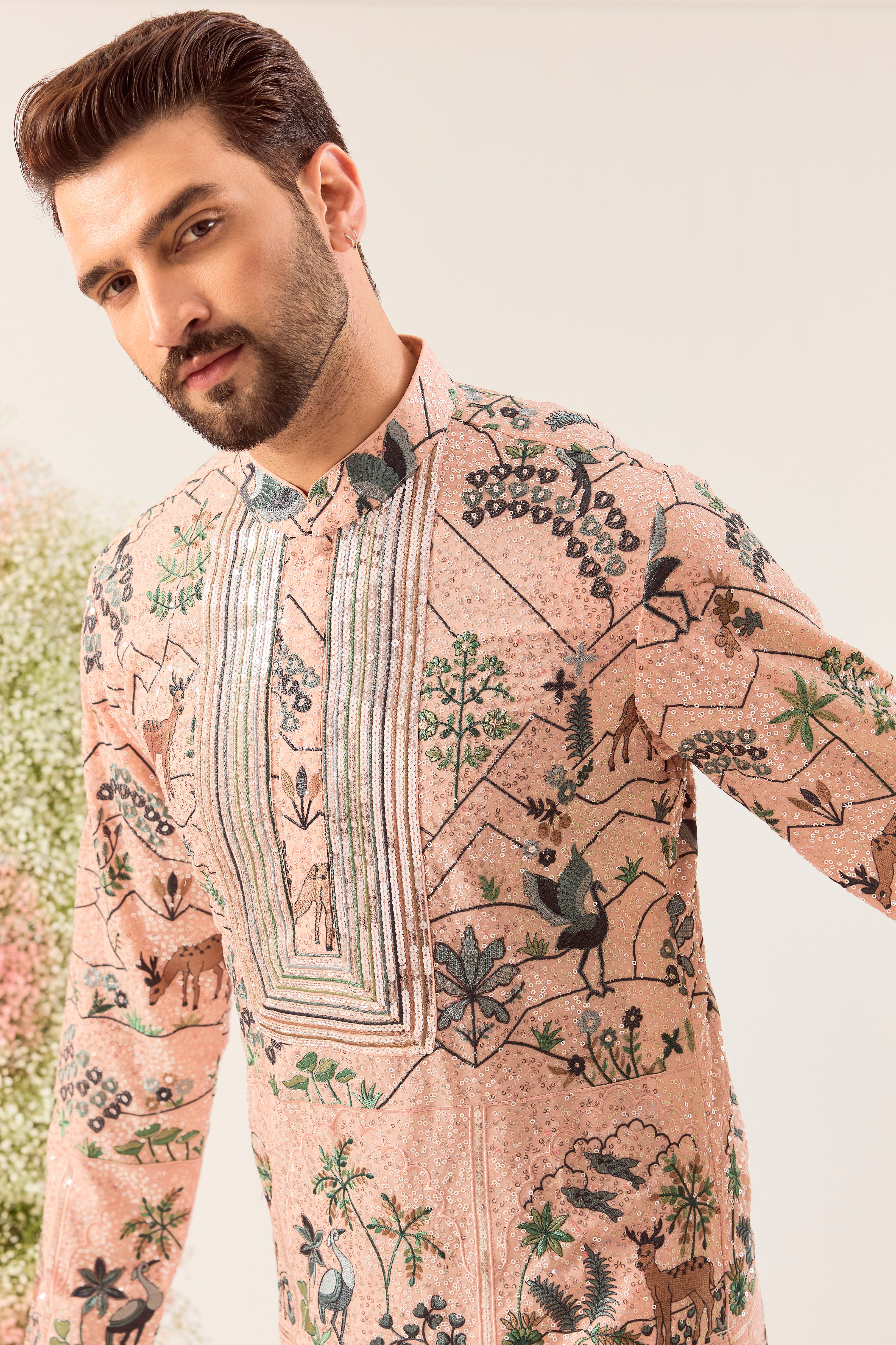 peach sequined kurta with detailed flora and fauna figures and intricate neckline