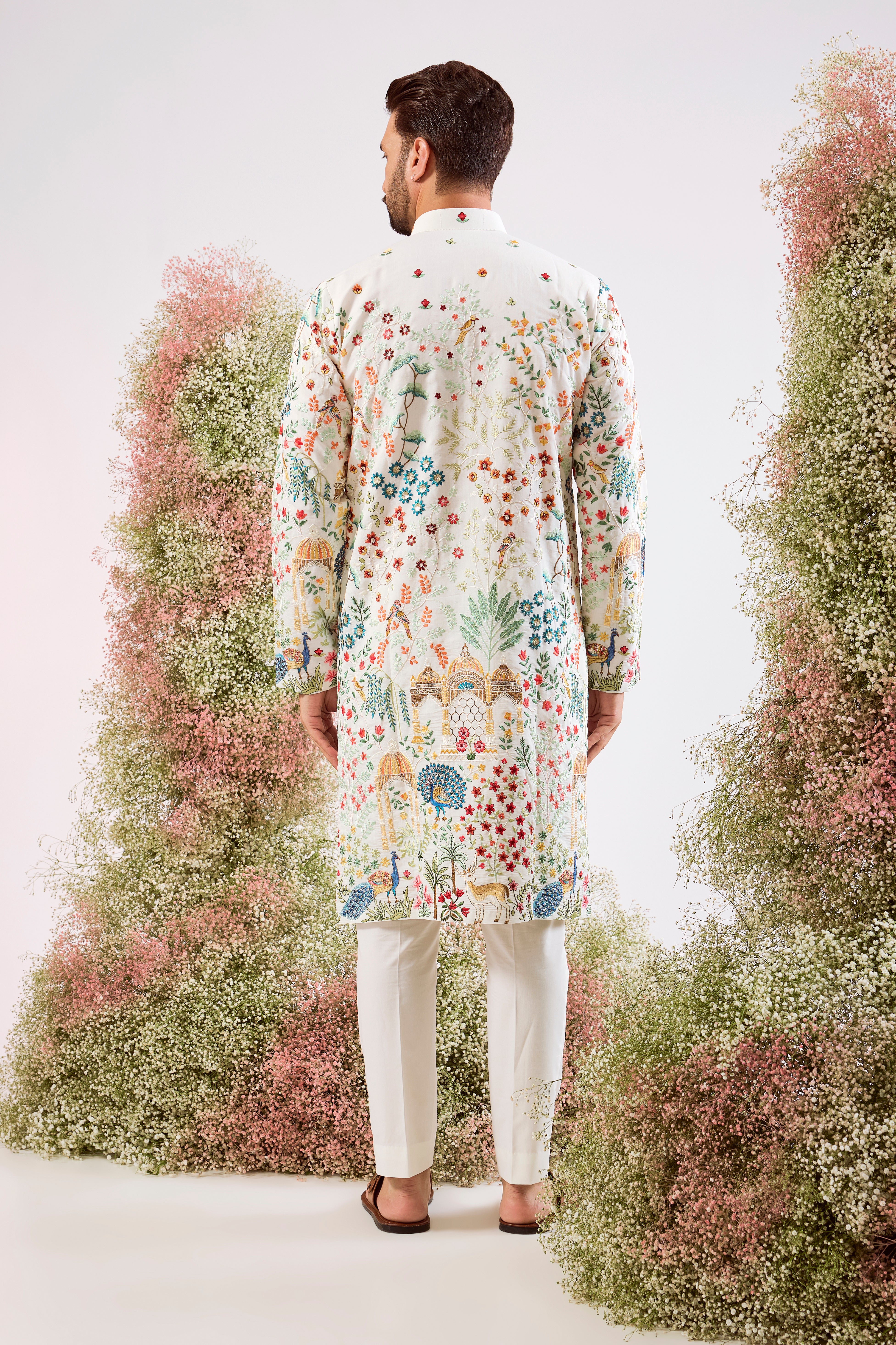 white royal heritage chikankari kurta with intricate interplay of flora and fauna and detailed mughar darbar figures