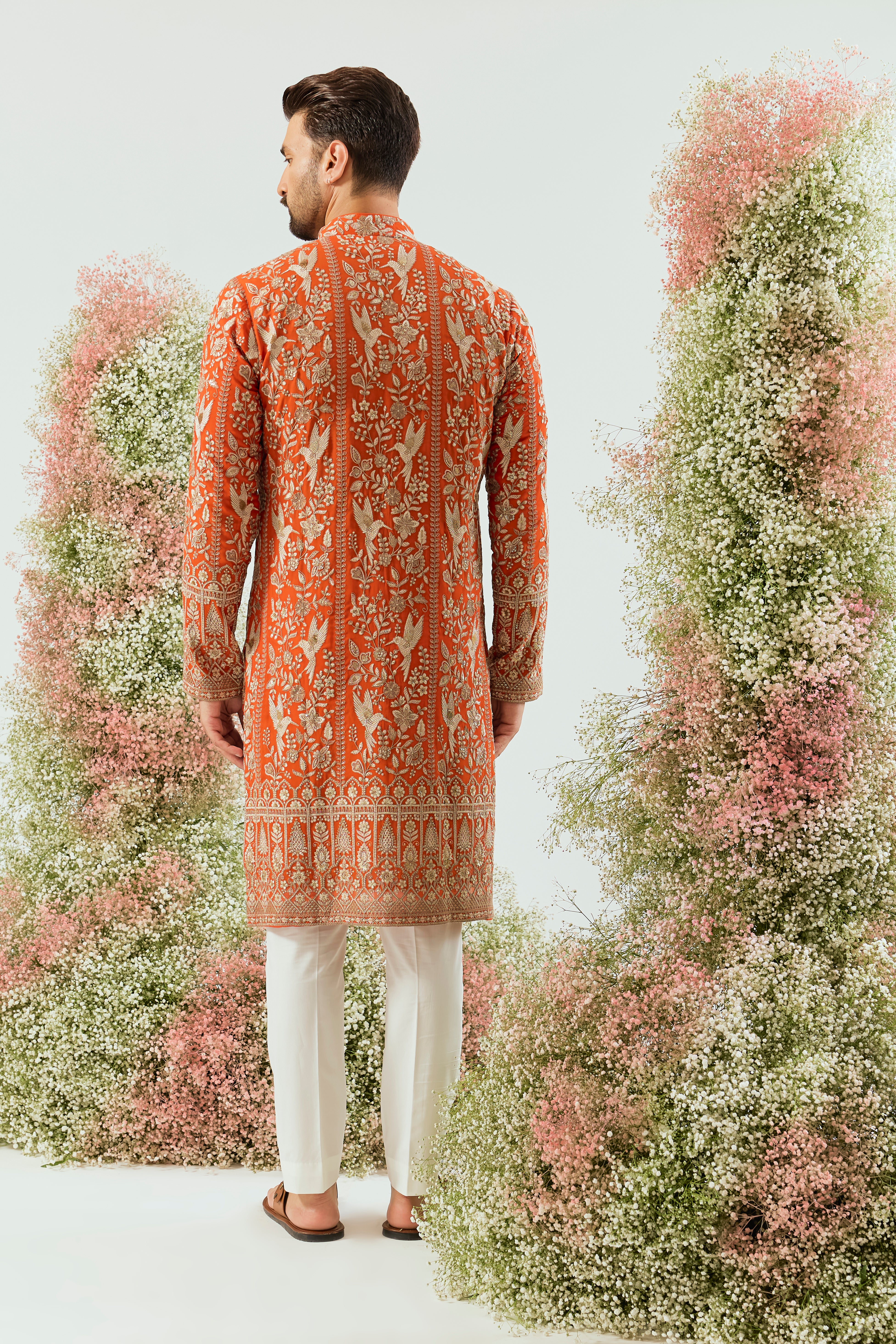 orange chikankari long kurta with intricate flora and fauna figures