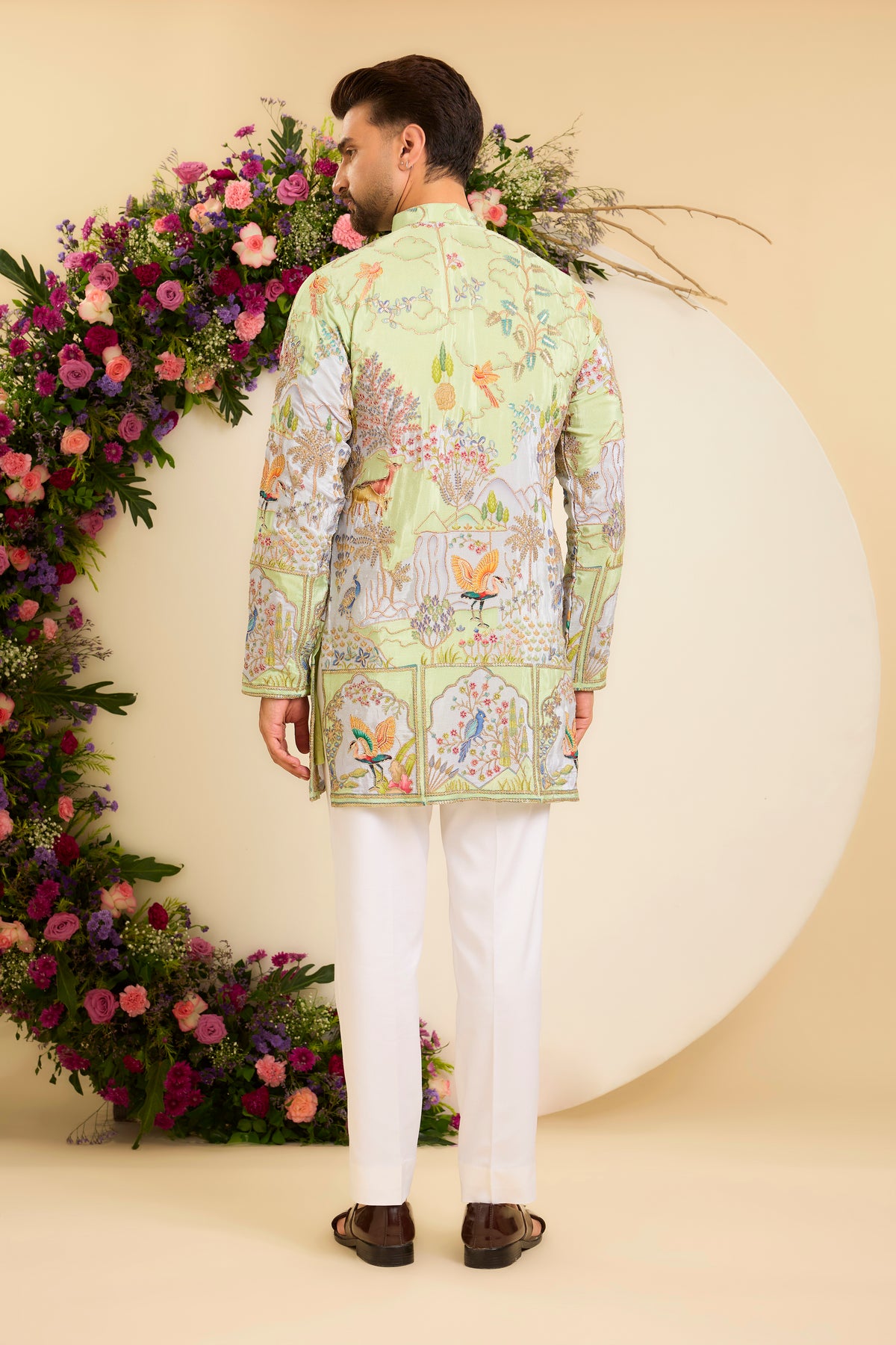 A Vibrant green Crepe short Kurta Richly Embroidered with Wildlife