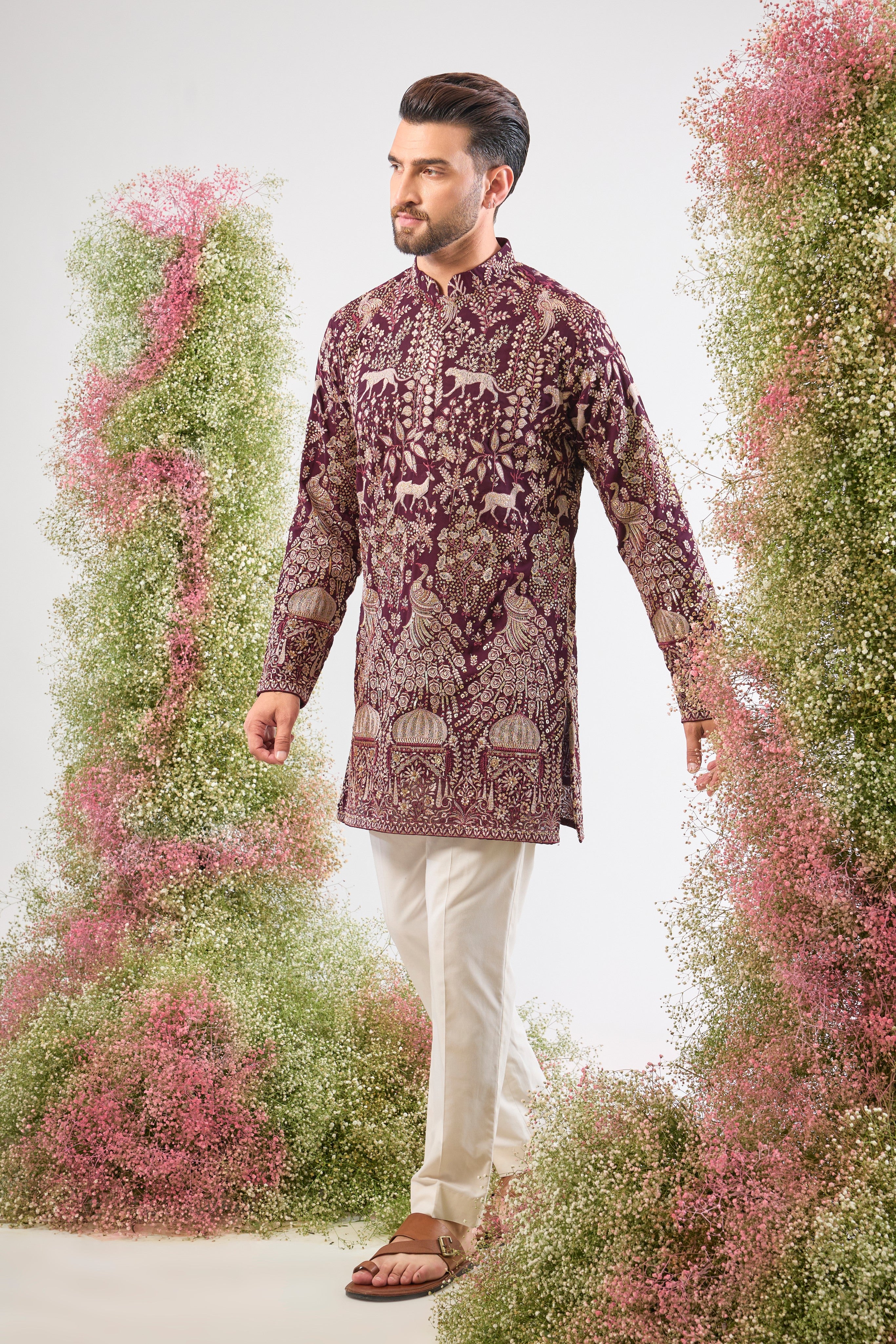 This Wine Short Kurta showcases stunning artistry, where Detailed Royal Darbars meet lush Flora and Fauna Figures. The entire design is beautifully textured and illuminated by rich Zari and Sequins.