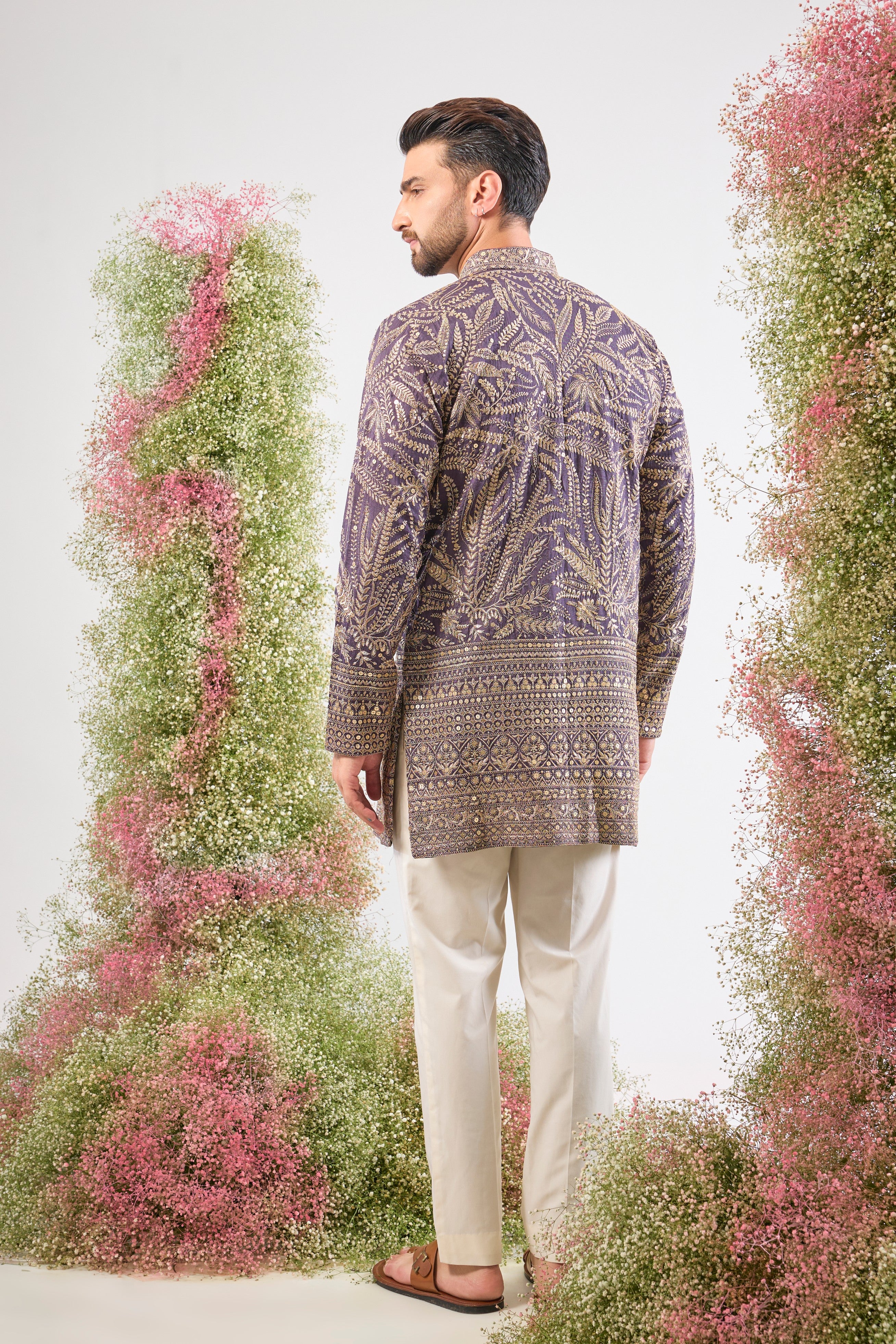 his Purple Mauve Short Zari Kurta is adorned with exquisite Detailed Floral Embroidery and shimmering sequins, creating incredible texture. The classic heavy ghera adds a majestic flow to the short silhouette.