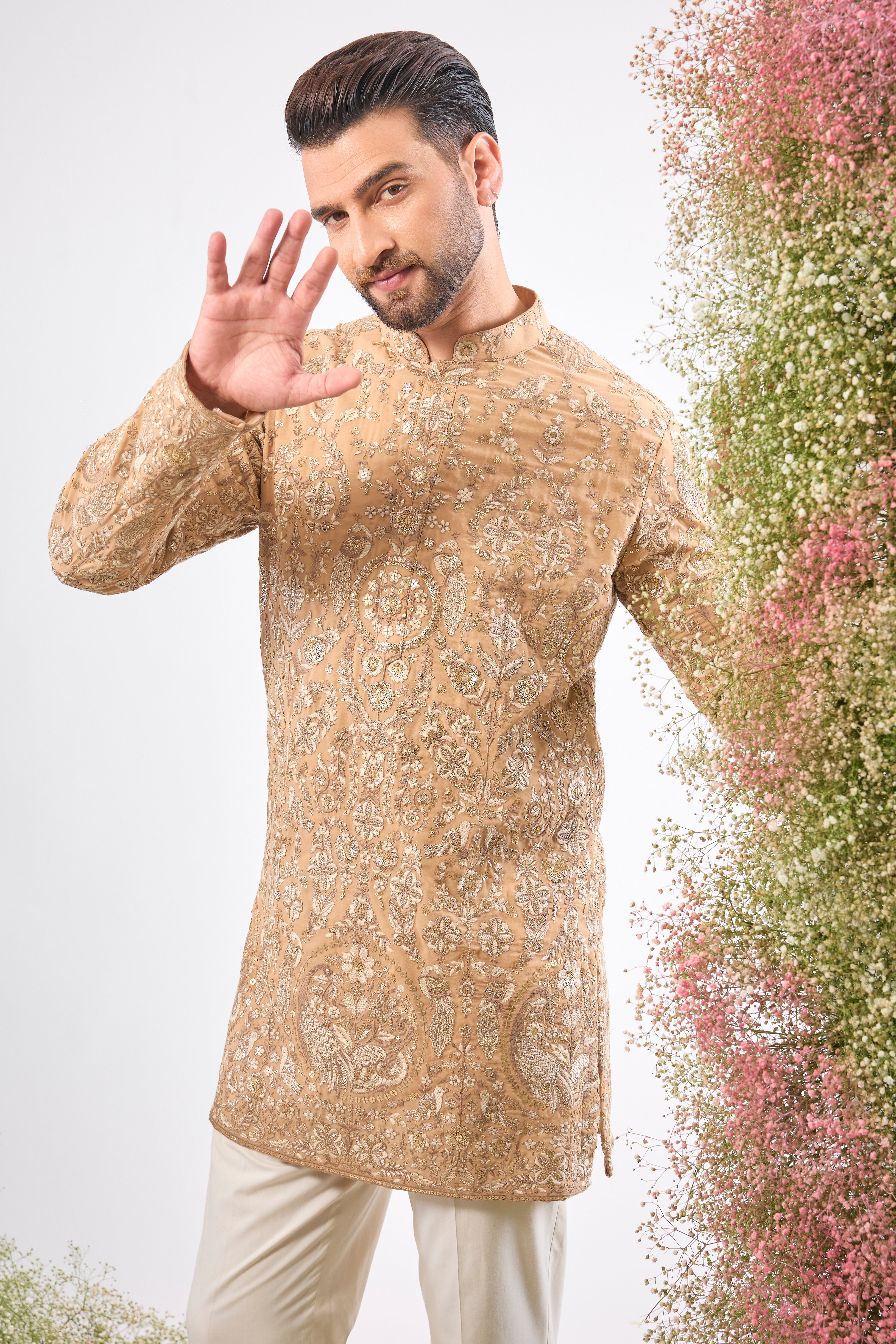 This Nude Short Kurta showcases magnificent Detailed Flora and Fauna Figures, creating depth and texture on the fabric. The combination of fine Zari and Sequin Work offers a delicate yet compelling shimmer.