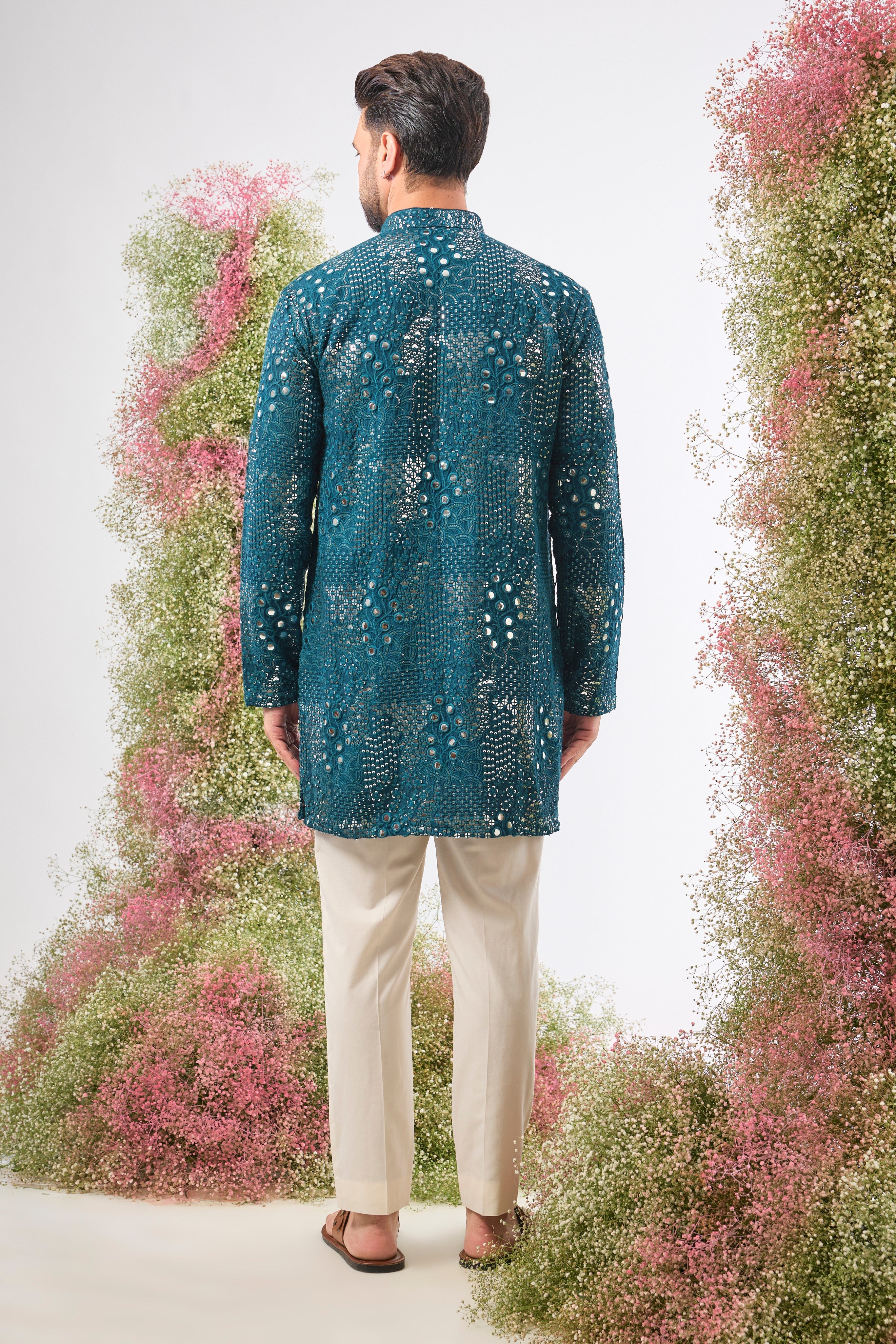 This Teal Mirror Work Kurta showcases exquisite Intricate Floral Patterns, beautifully highlighted by the reflective Sequin Work. The combination creates depth, vibrancy, and a continuous, captivating shimmer.