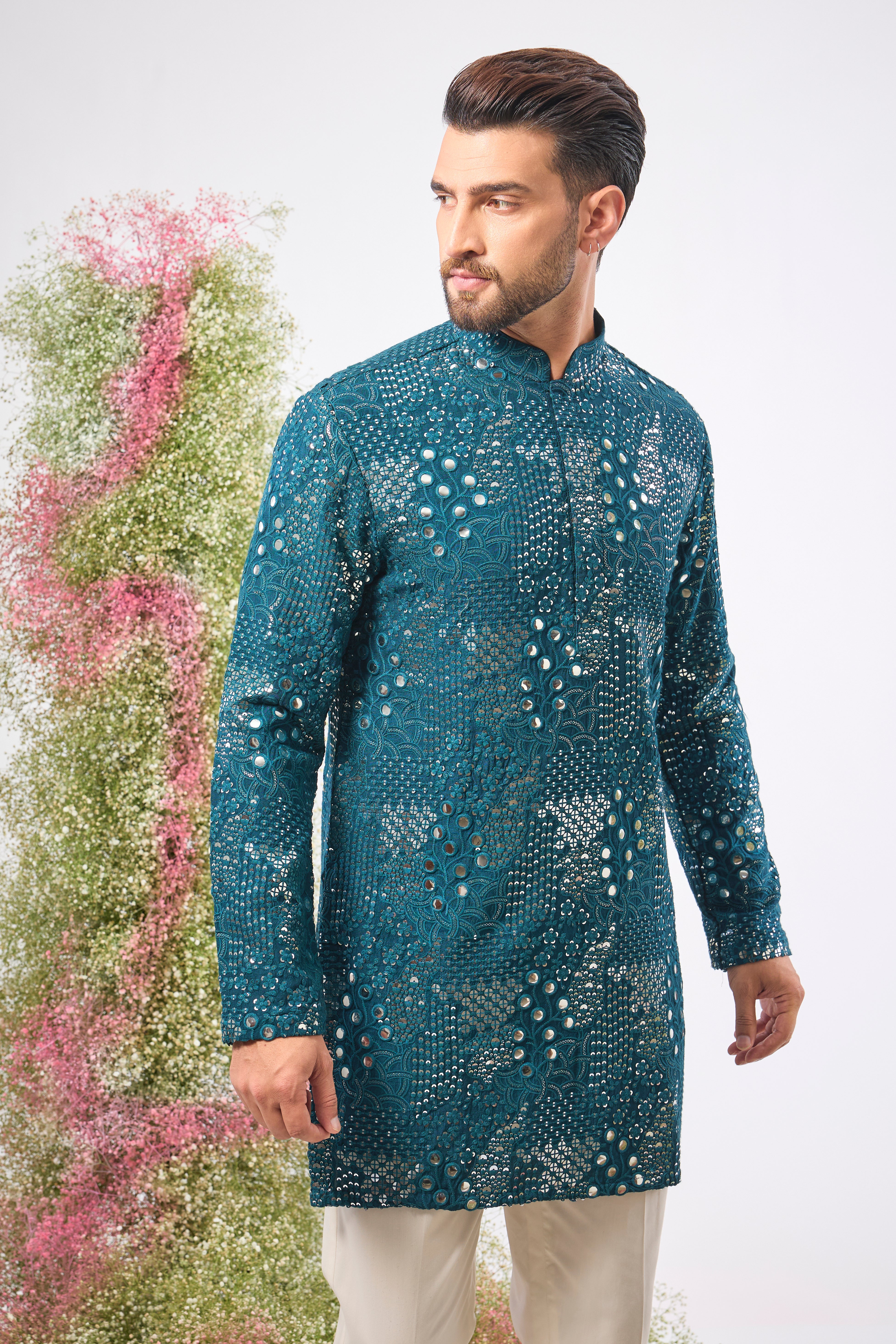 This Teal Mirror Work Kurta showcases exquisite Intricate Floral Patterns, beautifully highlighted by the reflective Sequin Work. The combination creates depth, vibrancy, and a continuous, captivating shimmer.