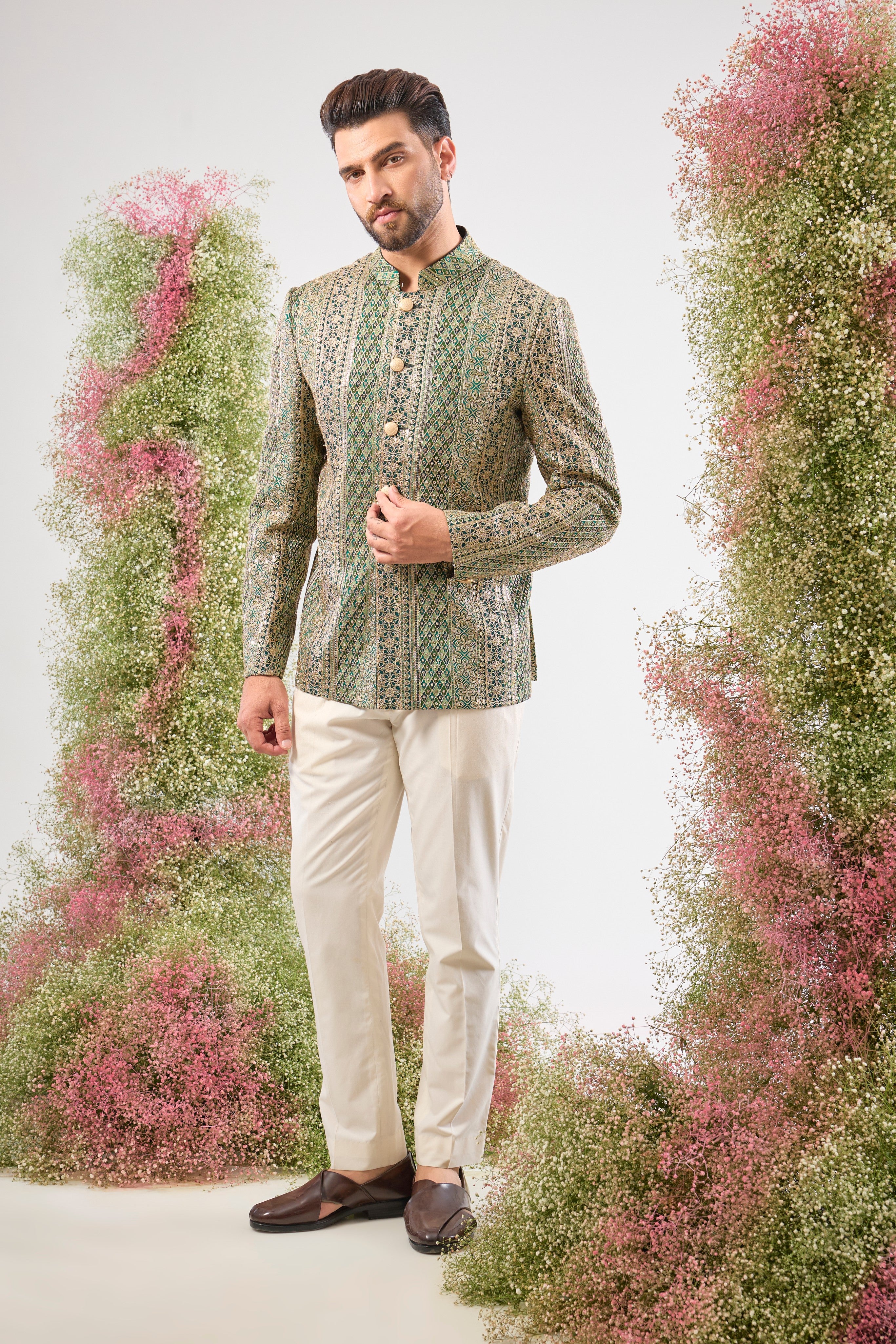 This Bottle Green Bandhgala is lavishly covered in Heavy Zari Work and sequin accents. The inclusion of Classy Metal Buttons ensures every detail of this garment speaks of high sophistication.