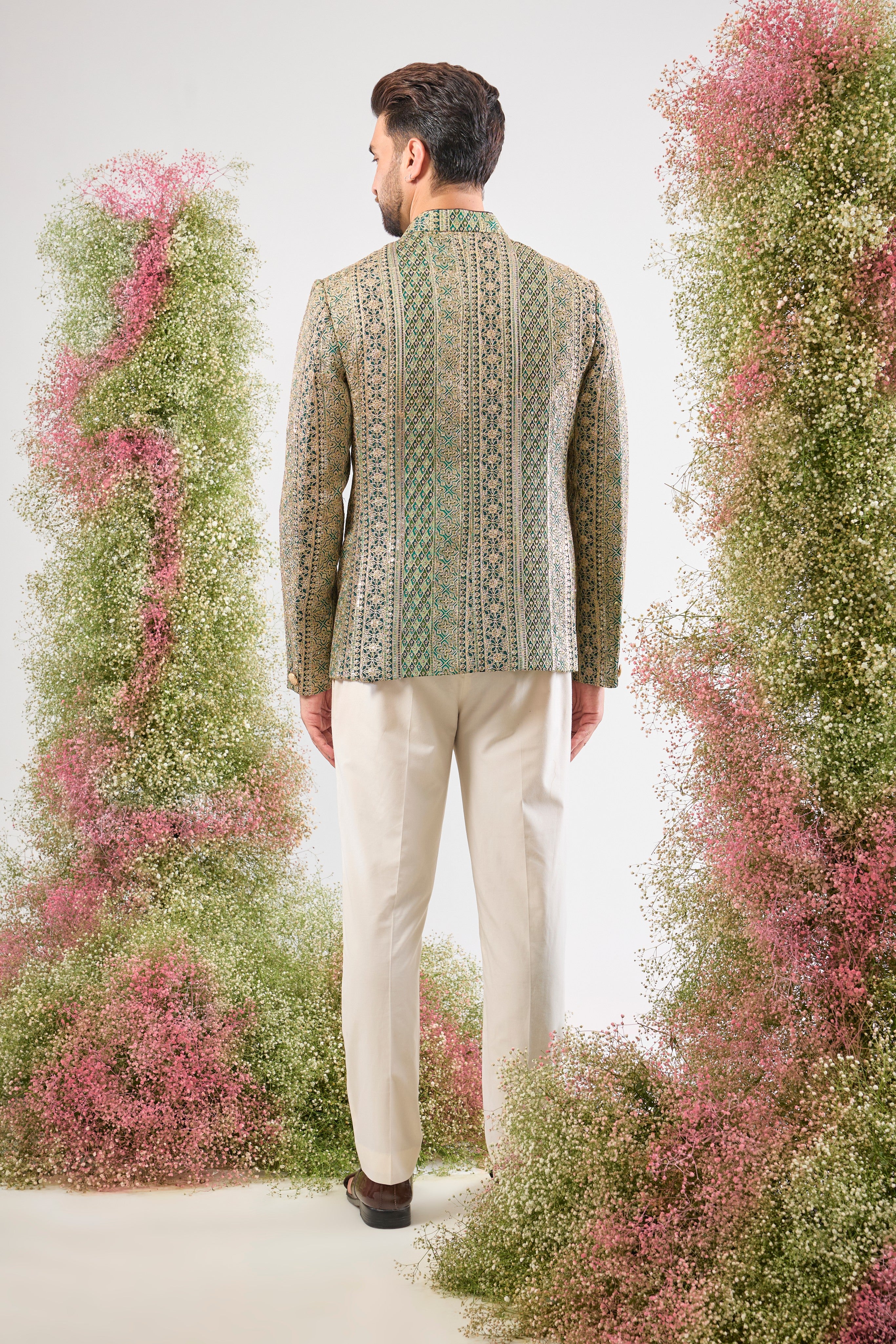 This Bottle Green Bandhgala is lavishly covered in Heavy Zari Work and sequin accents. The inclusion of Classy Metal Buttons ensures every detail of this garment speaks of high sophistication.