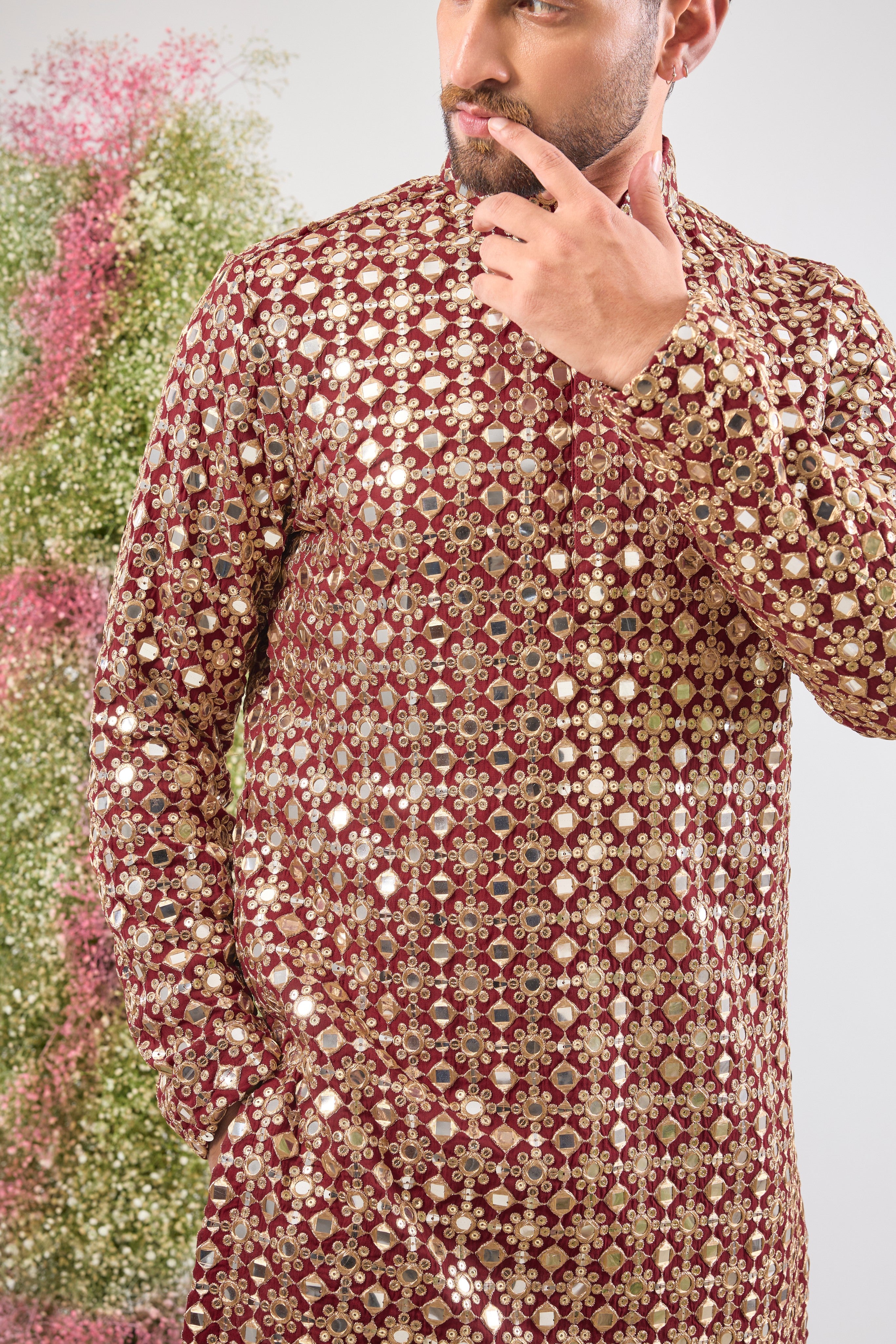 This Maroon Mirror Work Short Kurta showcases the dramatic texture of Heavy Zari Work, seamlessly blended with the brilliant shimmer of Detailed Sequins. The result is a garment that offers unmatched depth and sparkle, capturing light beautifully.