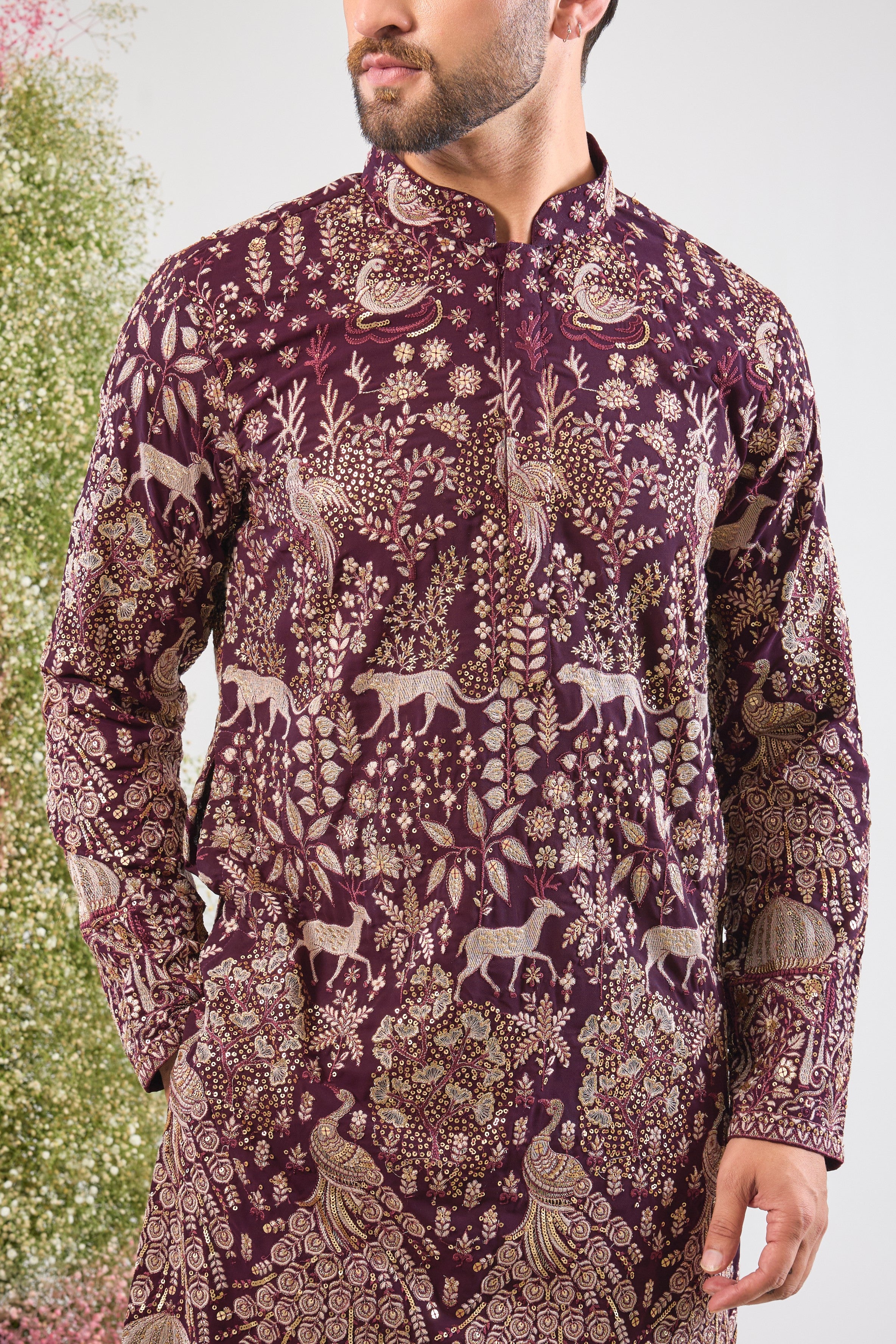 his Wine Long Kurta is super charming and very formal, showcasing intricate Royal Darbars alongside elegant Flora and Fauna motifs, all brought to life by dazzling Zari and Sequin work