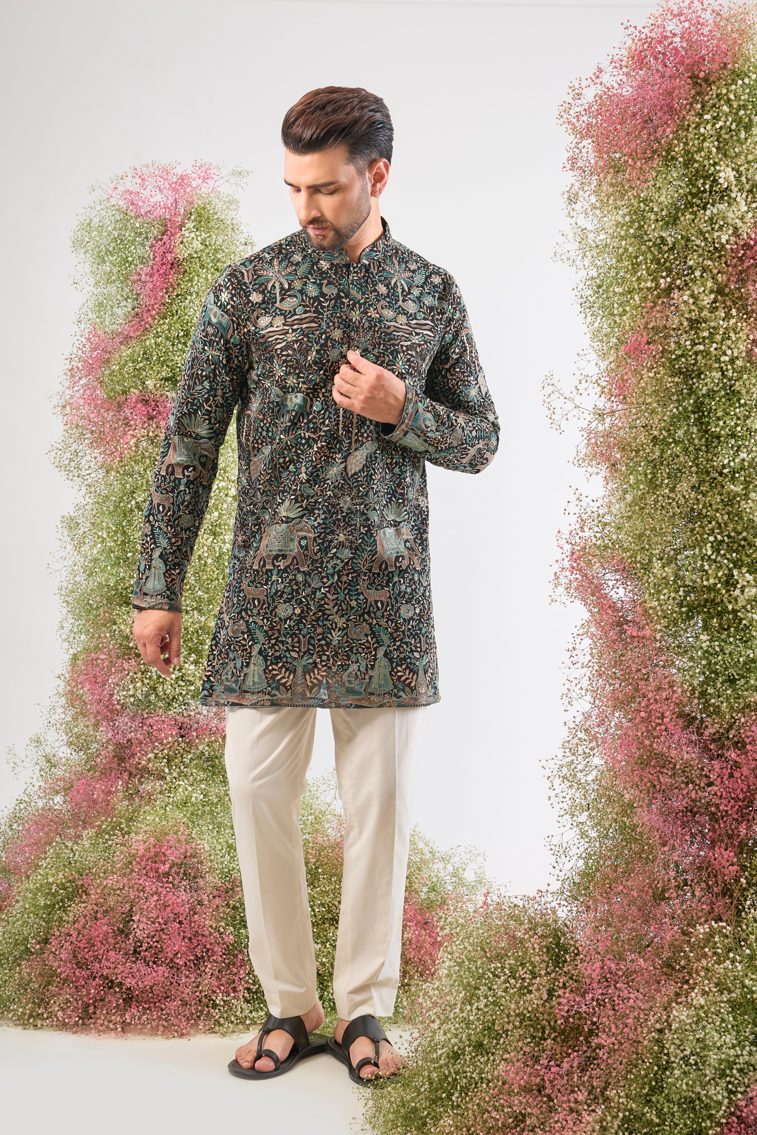 This Black Short Kurta is adorned with rich Kashmiri Embroidery, with every motif showcasing Detailed Flora and Fauna Embroidery. The sequin work provides a beautiful, reflective texture, ensuring a sophisticated and artistic presence at any event.