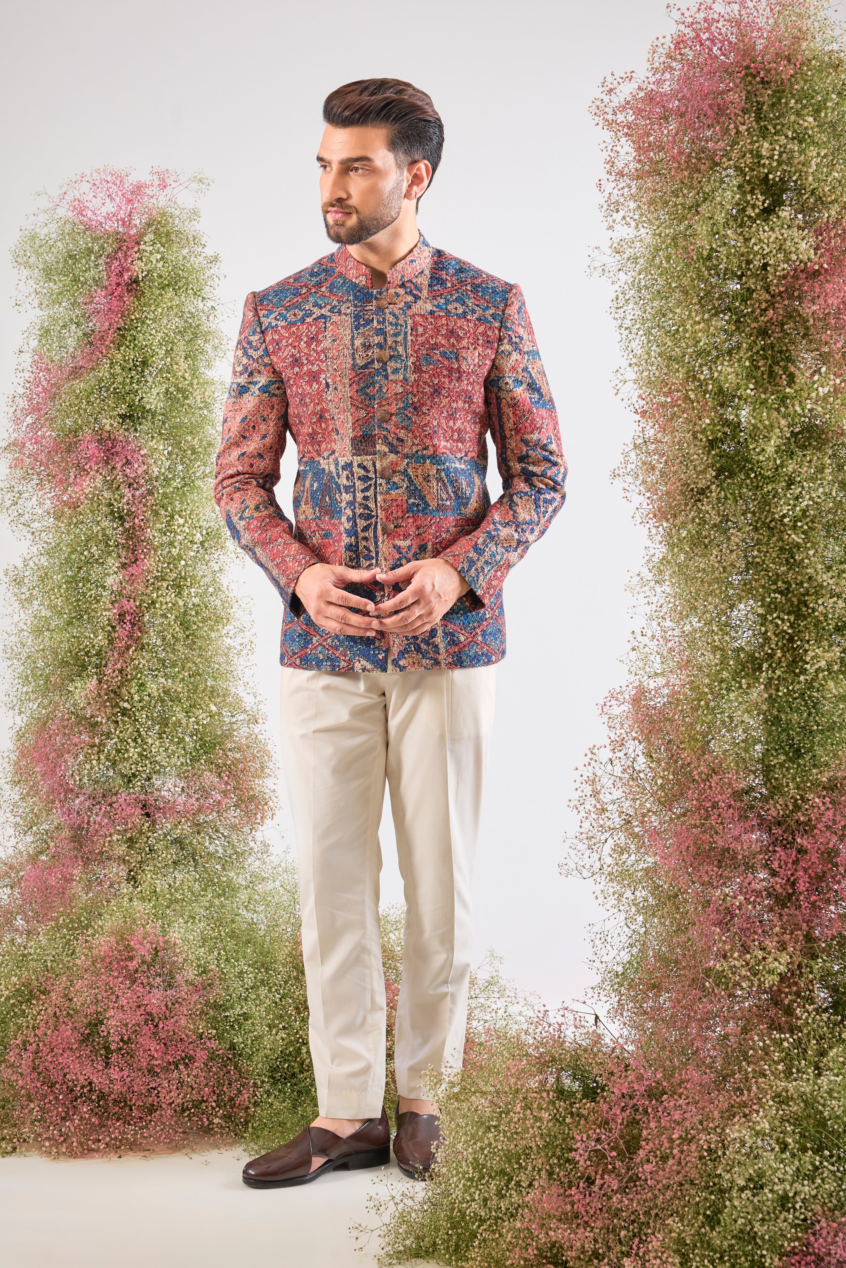 his Multi-coloured Bandhgala showcases a mesmerizing Abstract Royal Geometrical Print that is beautifully layered with fine Thread Work. The inclusion of Sequin Detailing ensures a subtle, festive shimmer, creating a truly dynamic and luxurious garment.