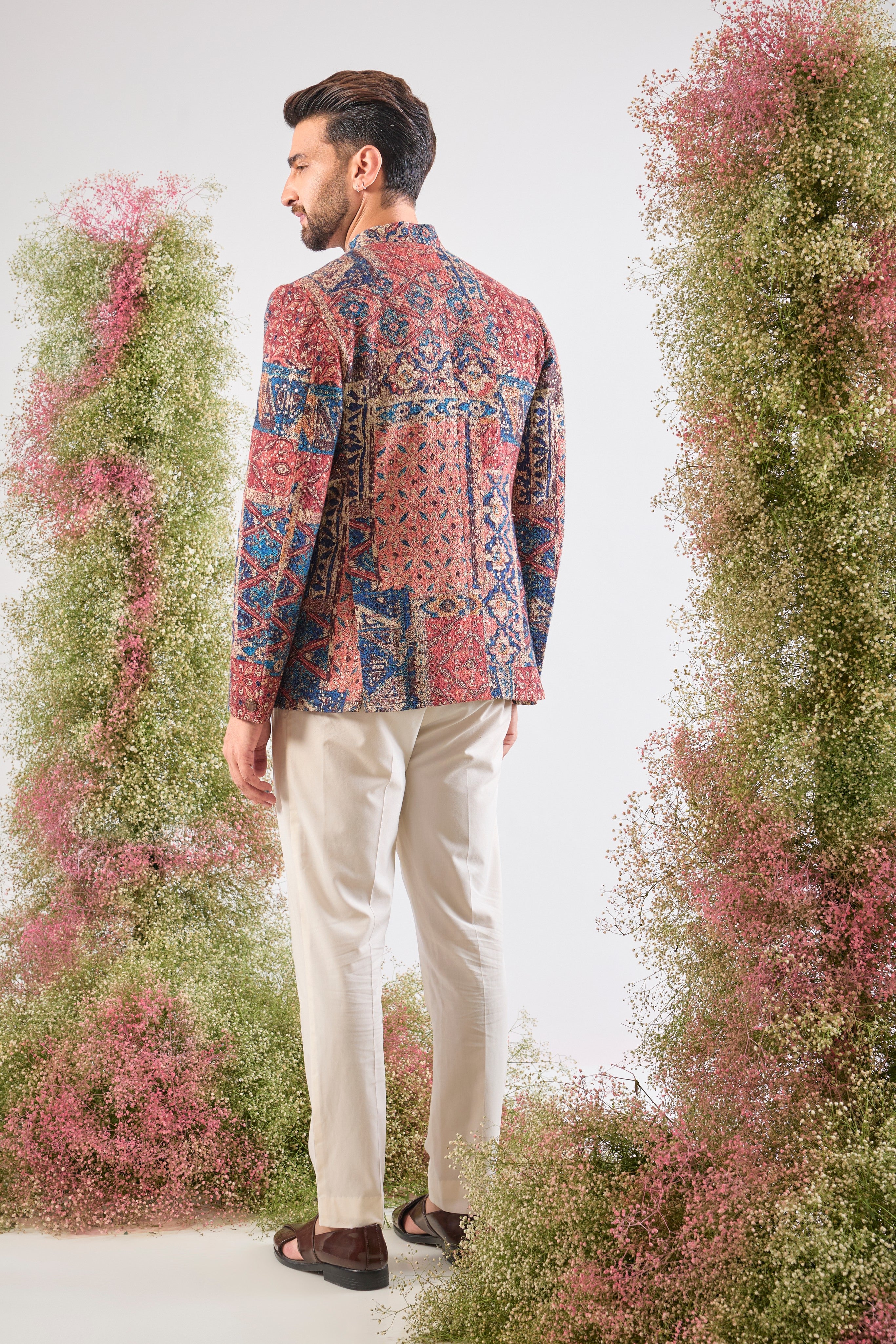 his Multi-coloured Bandhgala showcases a mesmerizing Abstract Royal Geometrical Print that is beautifully layered with fine Thread Work. The inclusion of Sequin Detailing ensures a subtle, festive shimmer, creating a truly dynamic and luxurious garment.