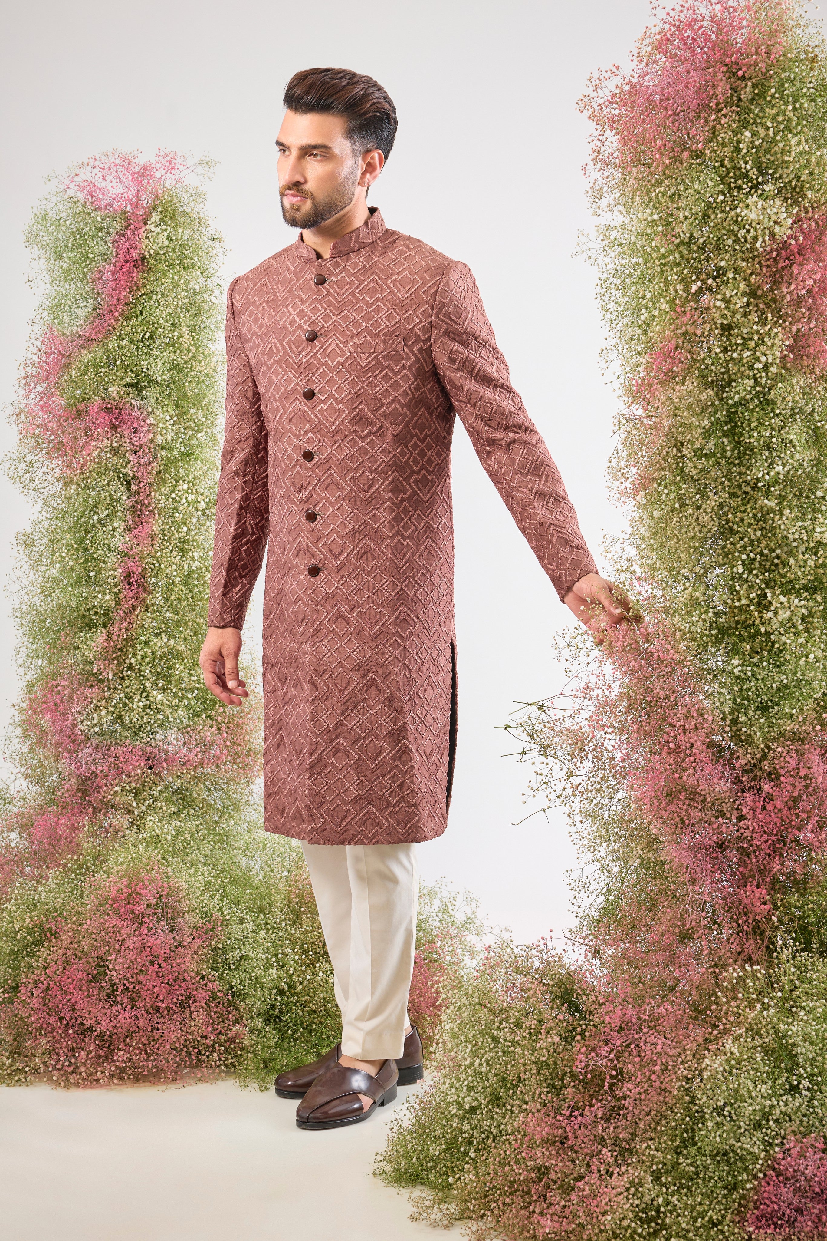 This Mauve Taupe Sherwani is a masterpiece of design, showcasing intense Heavy Thread Work in a mesmerizing Geometrical Pattern across the luxurious silk fabric.