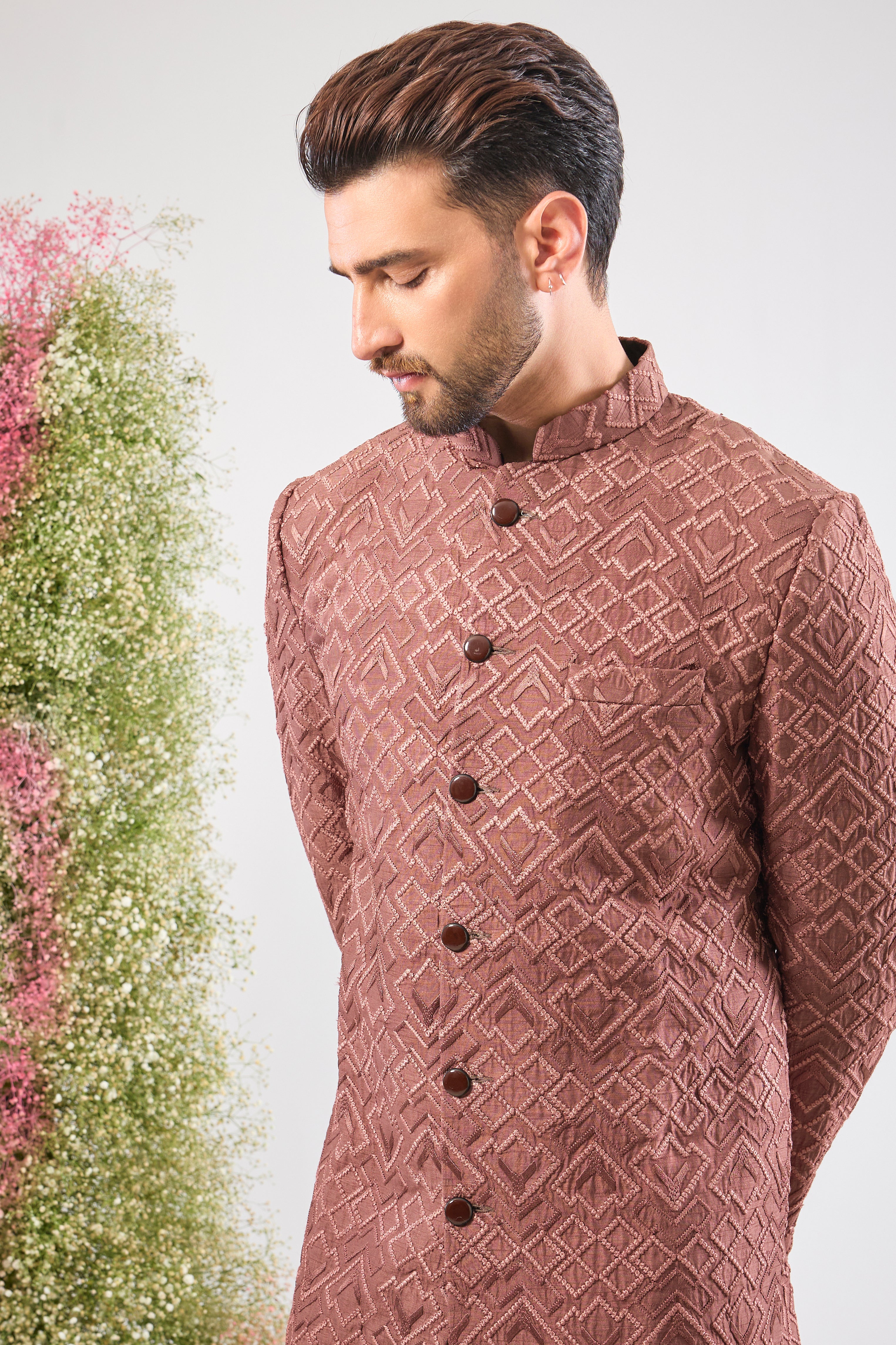 This Mauve Taupe Sherwani is a masterpiece of design, showcasing intense Heavy Thread Work in a mesmerizing Geometrical Pattern across the luxurious silk fabric.