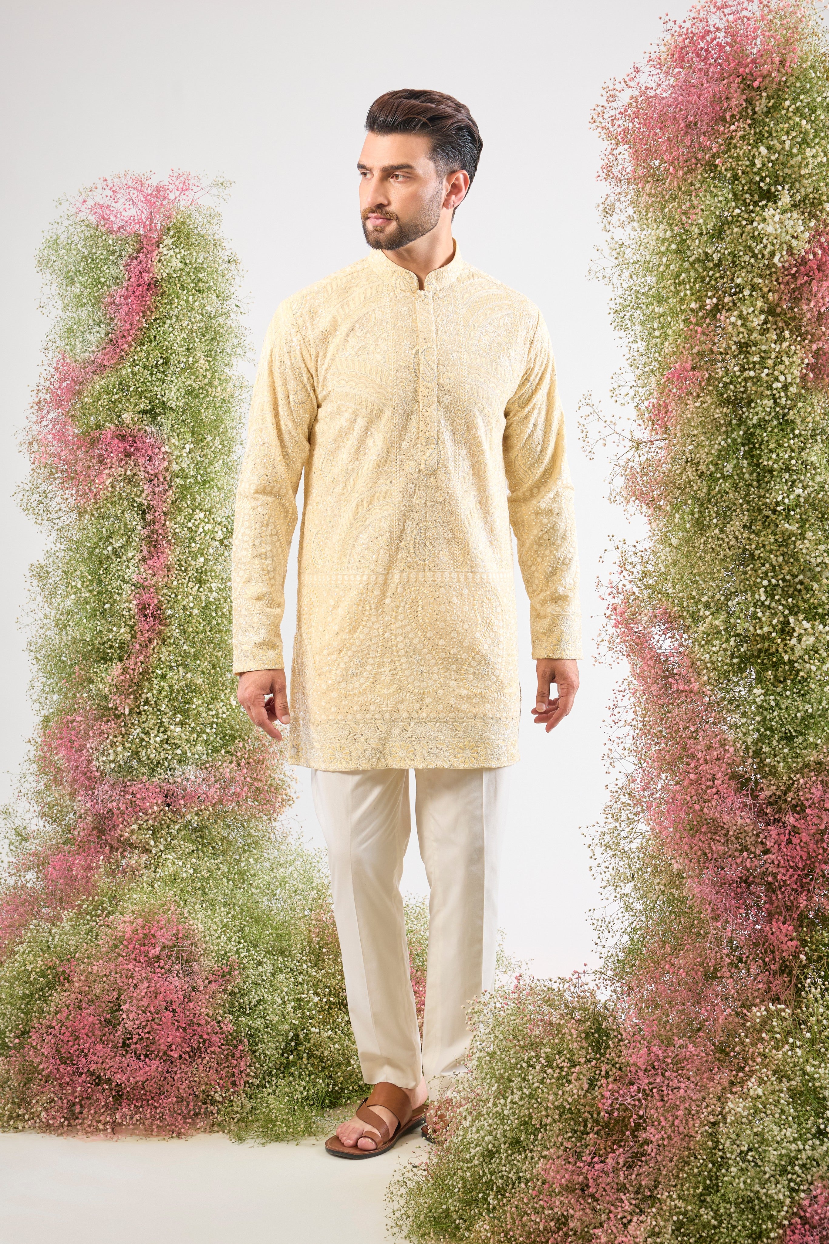 This Pastel Yellow Chikankari Short Kurta is adorned with rich Cream and Yellow Thread Work, enhancing the traditional craft.