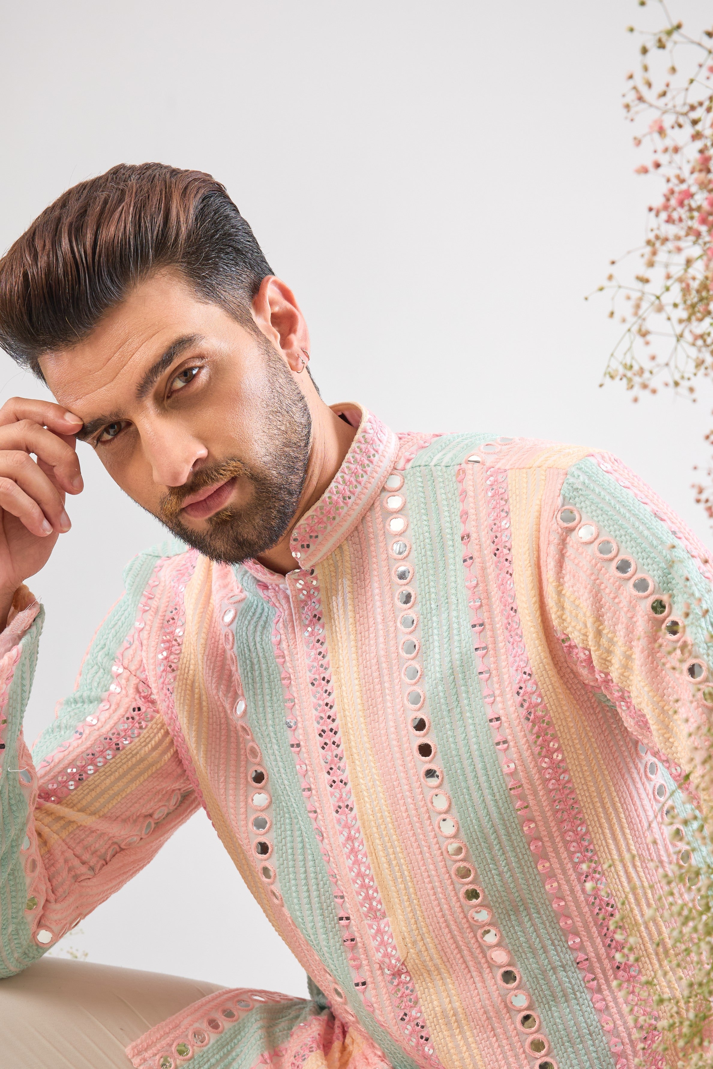 This Short Mirror Work Kurta showcases structured Pintucks Style Stripes filled with rich Multi-coloured Thread work, subtly enhanced by Delicate Sequin Work. The combination is utterly magical, offering a sophisticated yet joyful aesthetic.