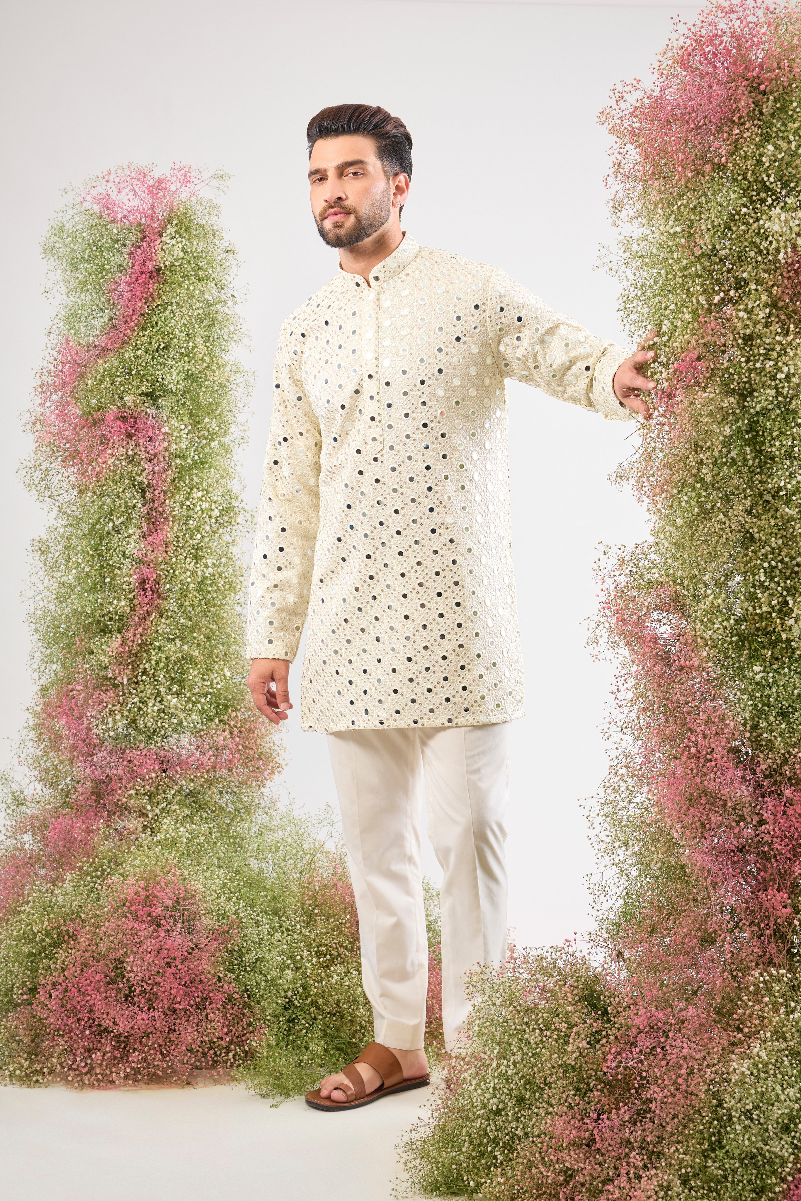 his White Short Mirror Work Kurta showcases the weight and brilliance of Detailed Heavy Sequin Work, providing a richly textured, luminous surface. The pristine white colour enhances the sparkle, ensuring a truly show-stopping look