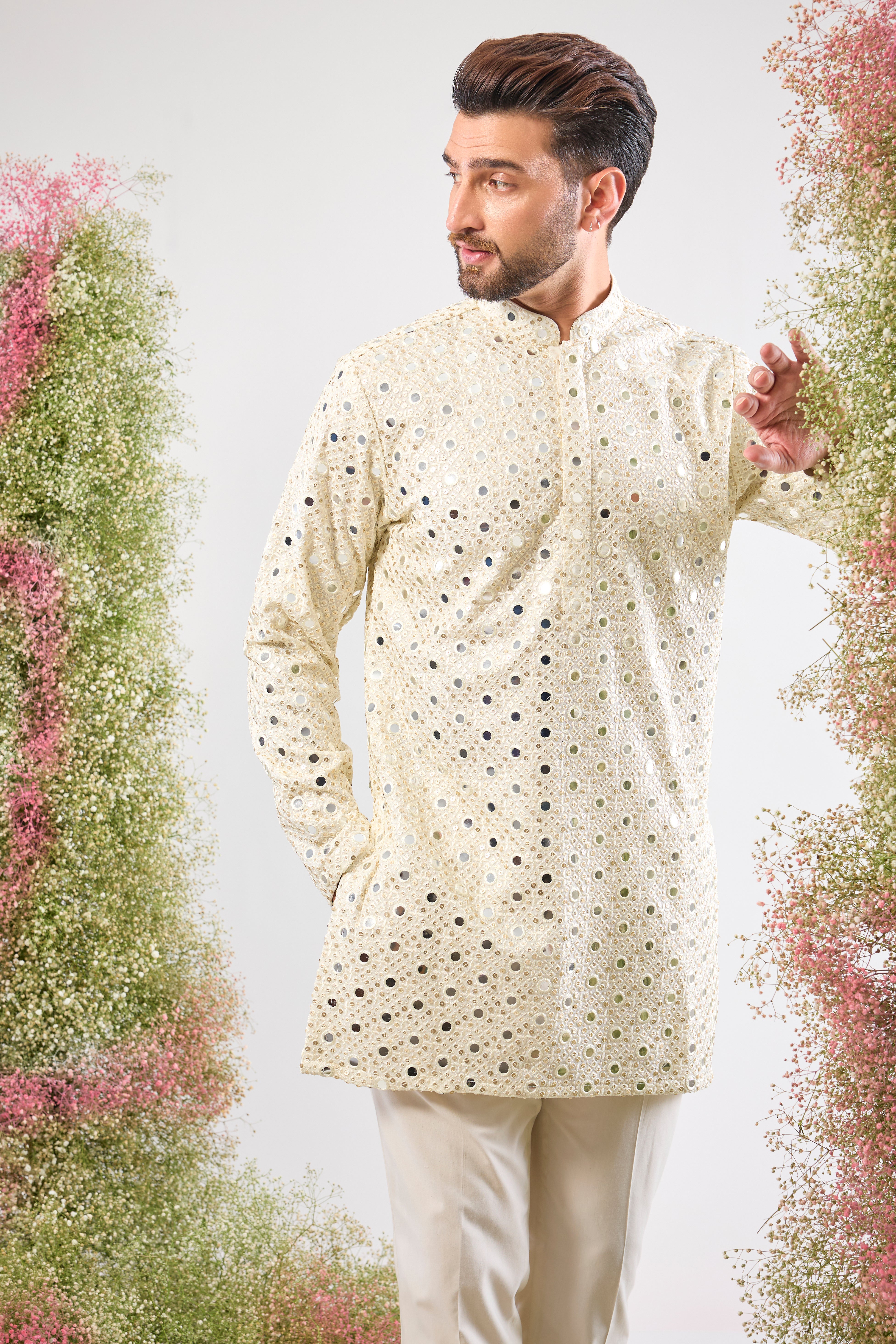 his White Short Mirror Work Kurta showcases the weight and brilliance of Detailed Heavy Sequin Work, providing a richly textured, luminous surface. The pristine white colour enhances the sparkle, ensuring a truly show-stopping look