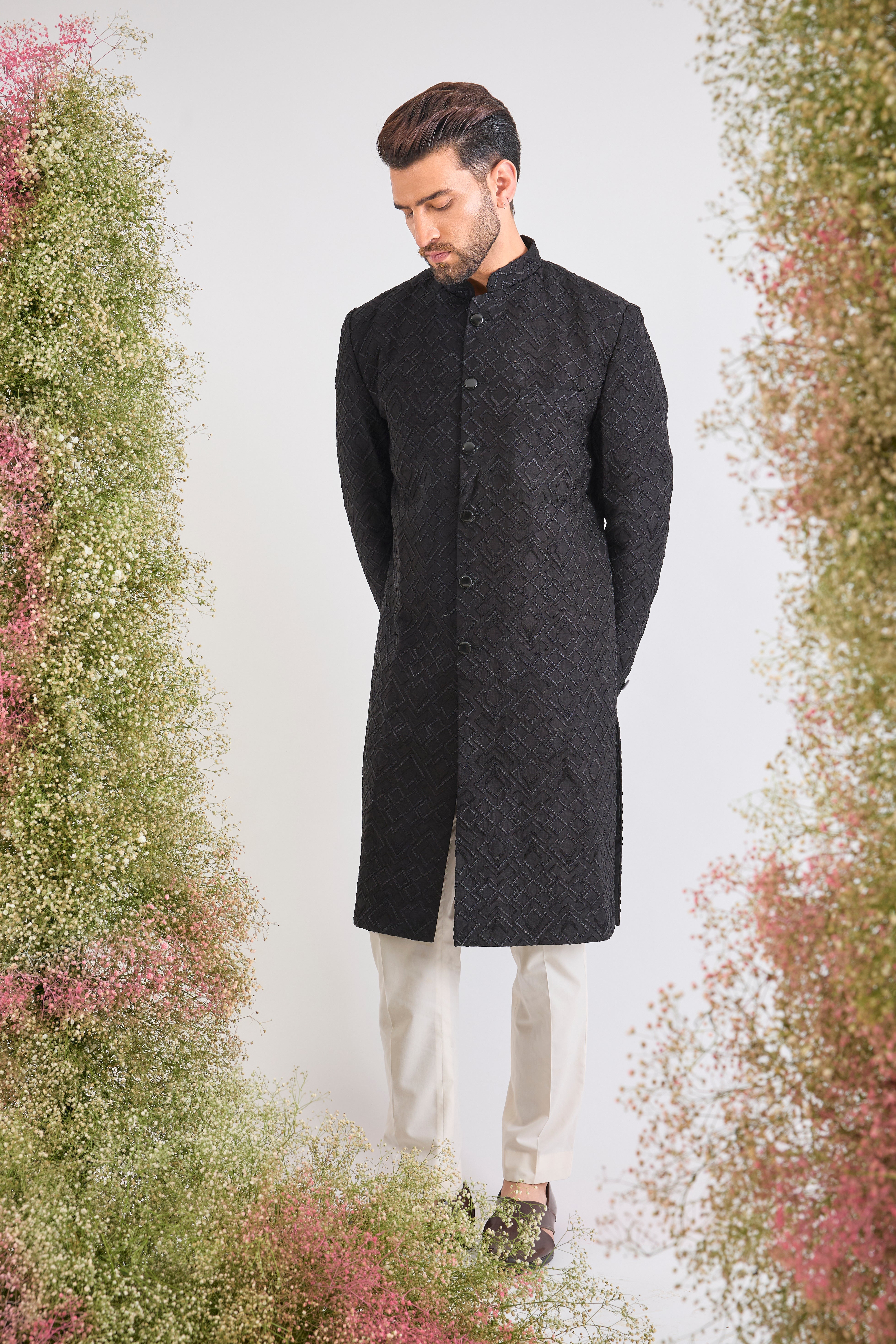 This Sherwani showcases a striking Geometrical Design through Tone-to-Tone Heavy Thread Work, offering unmatched richness and texture.