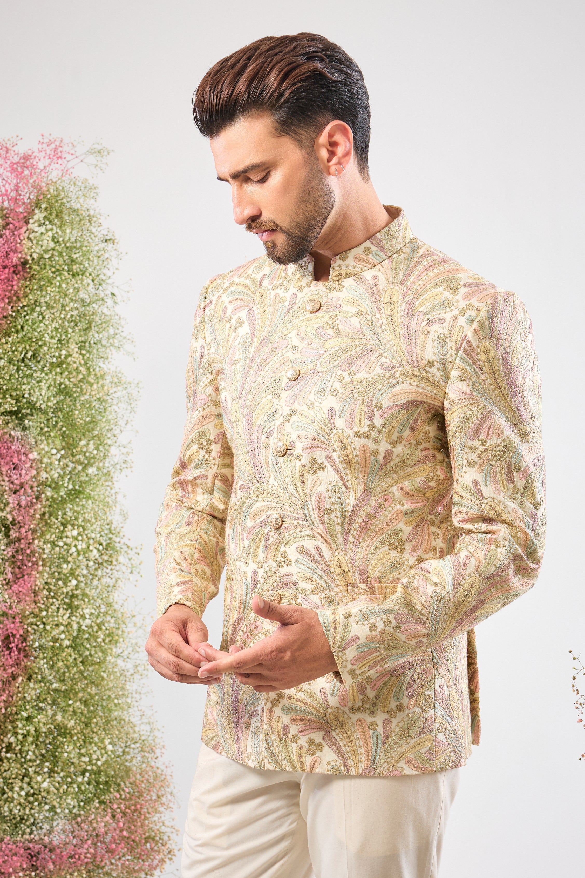 This Multi-coloured Floral Bandhgala beautifully combines intricate Floral Embroidery and rich Multi-thread Work. The design is elevated by subtle Zari Touches and Sequins for a festive sparkle, while White Metal Buttons provide a clean, elegant finish