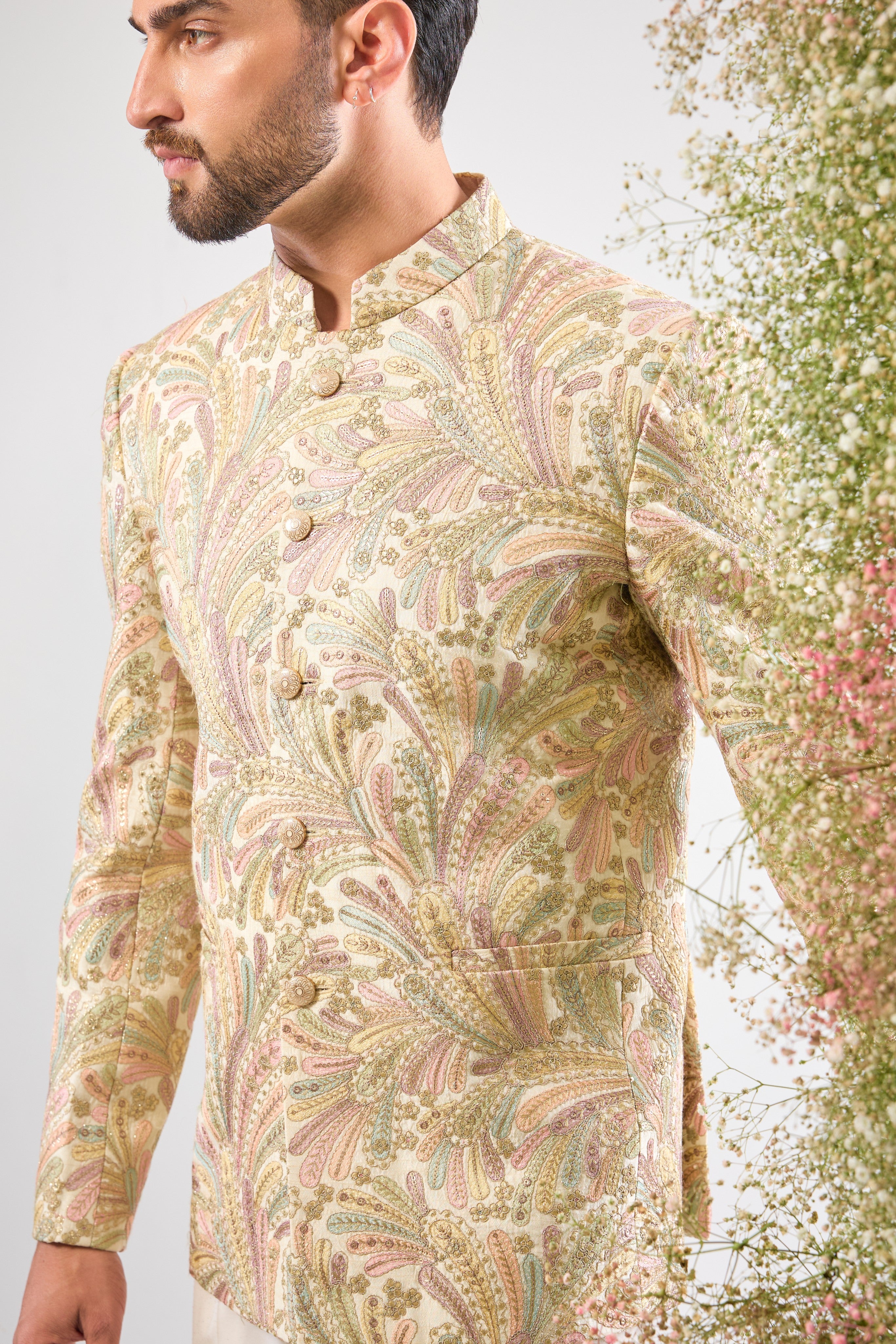 This Multi-coloured Floral Bandhgala beautifully combines intricate Floral Embroidery and rich Multi-thread Work. The design is elevated by subtle Zari Touches and Sequins for a festive sparkle, while White Metal Buttons provide a clean, elegant finish