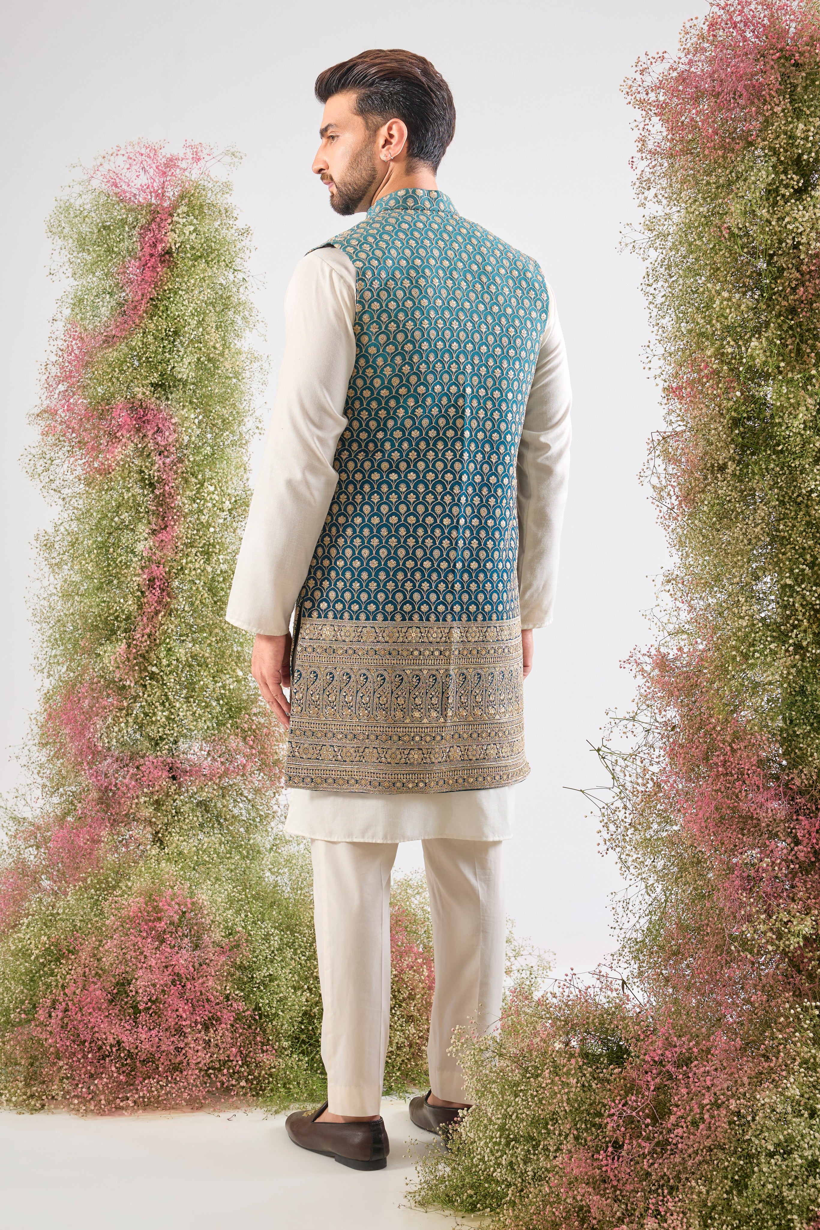 his Ombre Shaded Blue Long Open Jacket showcases an exquisite gradient and is lavishly detailed with Heavy Zari Work, providing depth and shimmer.