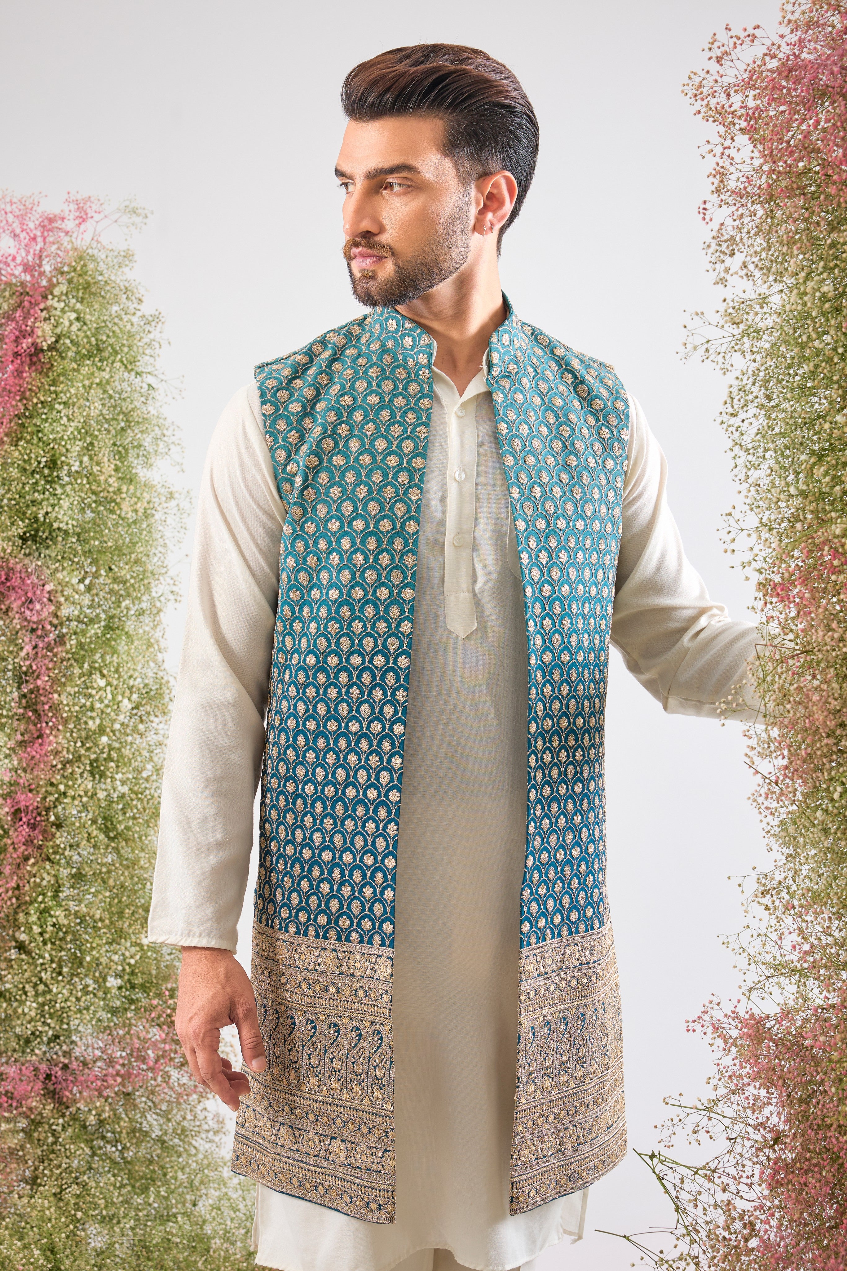 his Ombre Shaded Blue Long Open Jacket showcases an exquisite gradient and is lavishly detailed with Heavy Zari Work, providing depth and shimmer.