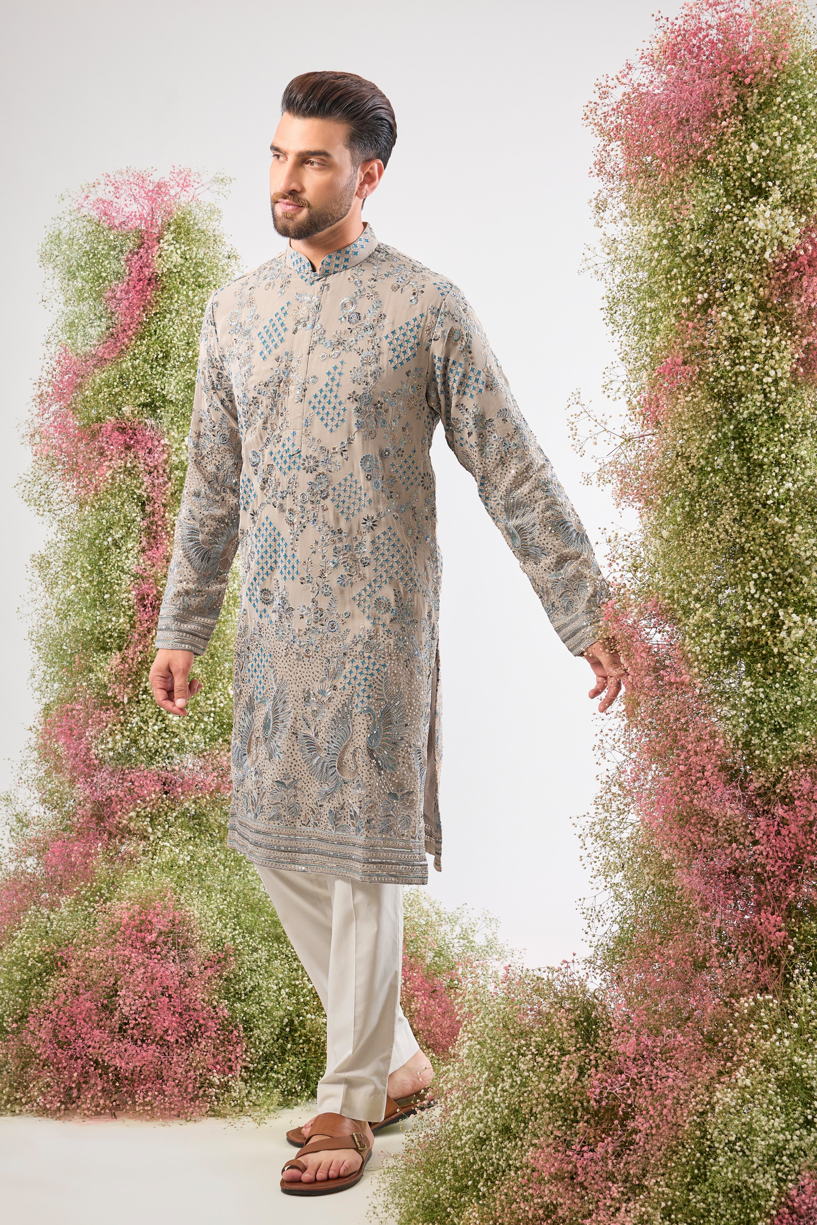 This Nude Coloured Long Kurta showcases magnificent Detailed Flora and Fauna Embroidery, executed with vibrant Multi-thread Work.