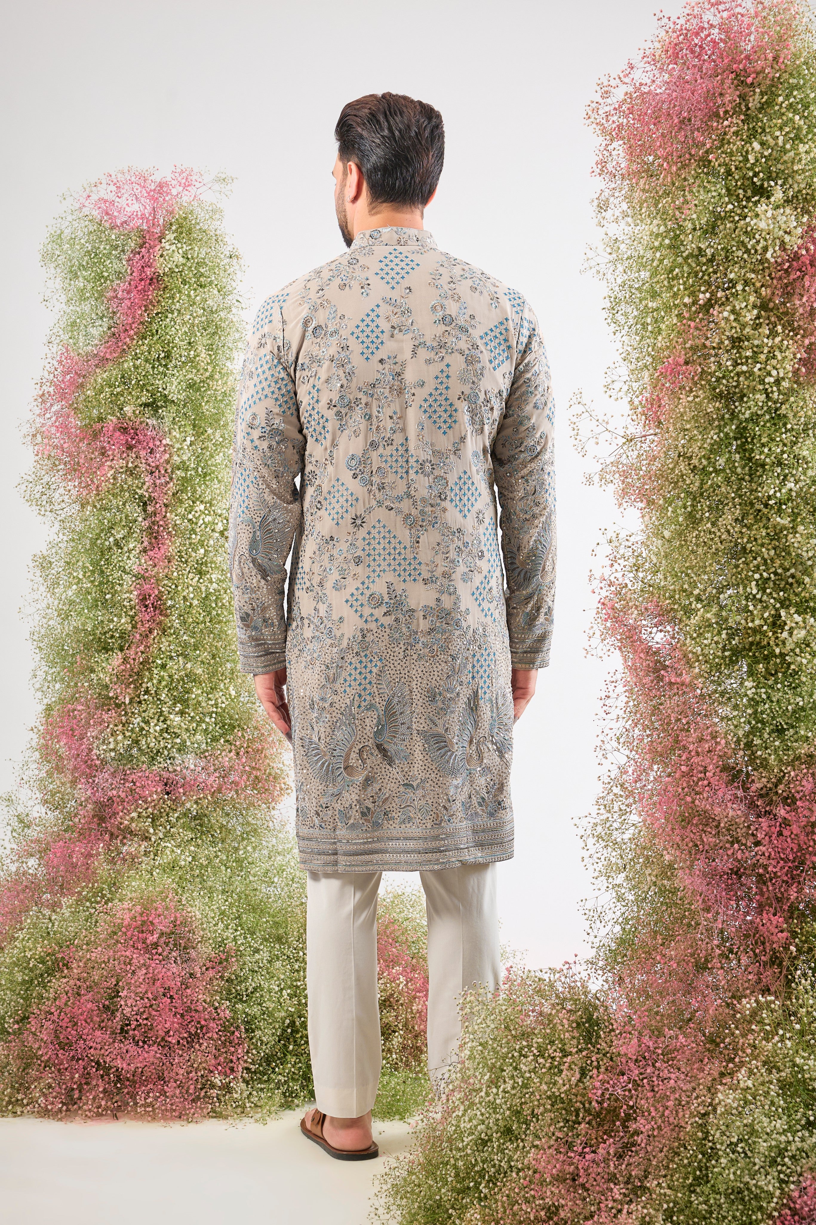This Nude Coloured Long Kurta showcases magnificent Detailed Flora and Fauna Embroidery, executed with vibrant Multi-thread Work.